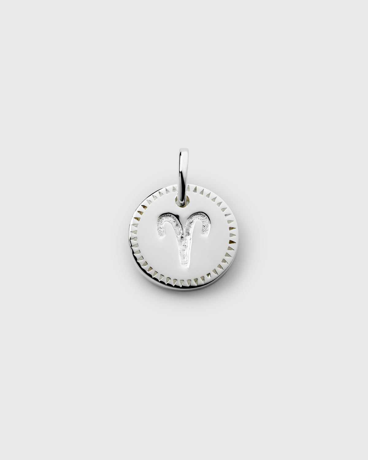 A product shot of the Beloved Zodie Pendant in silver, showcasing the Aries variant with its engraved zodiac symbol and a decorative triangular border.
