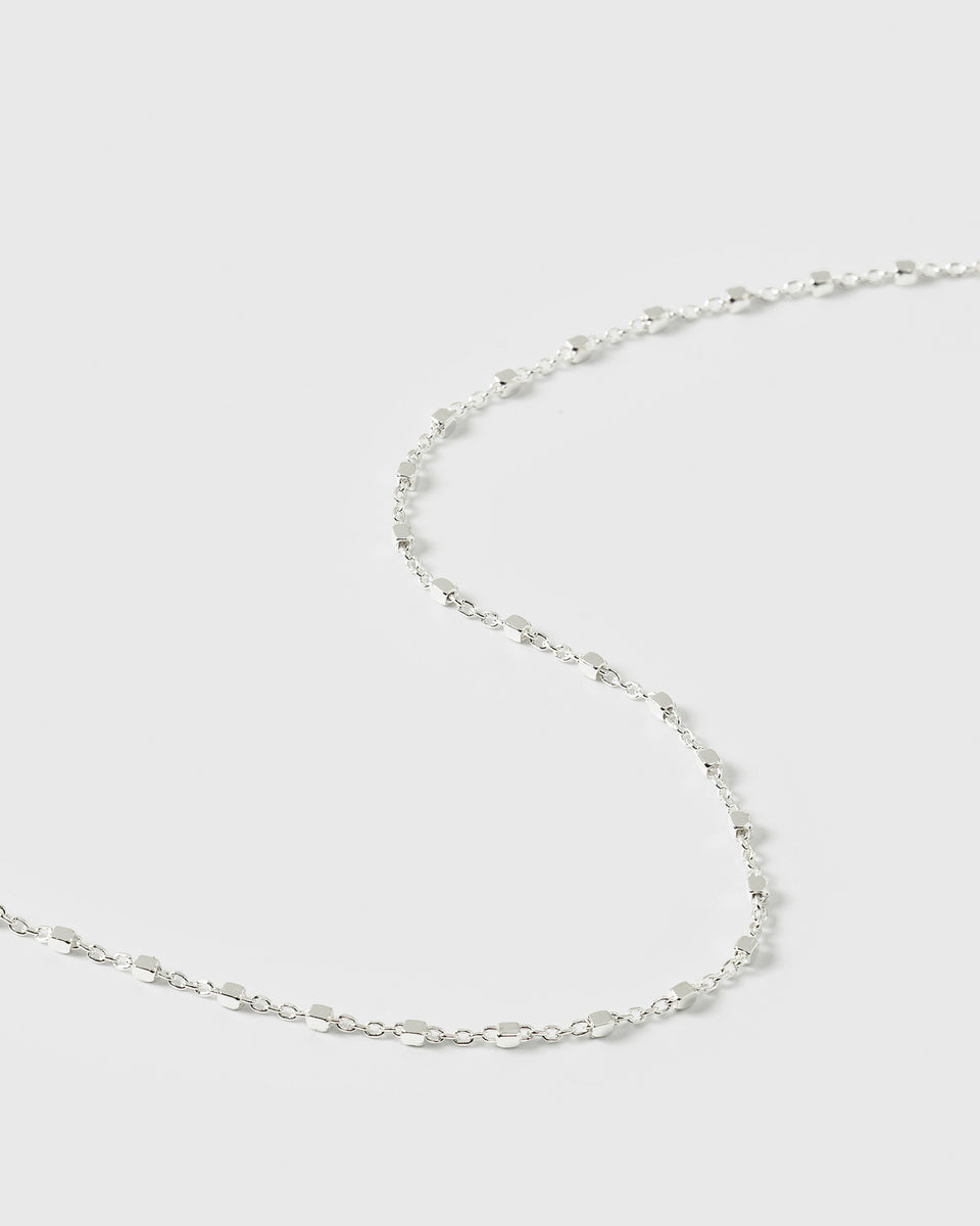 A close-up product shot of the Sheer Station Bracelet in silver, highlighting its delicate design of a fine chain with small, evenly spaced cube-shaped beads.