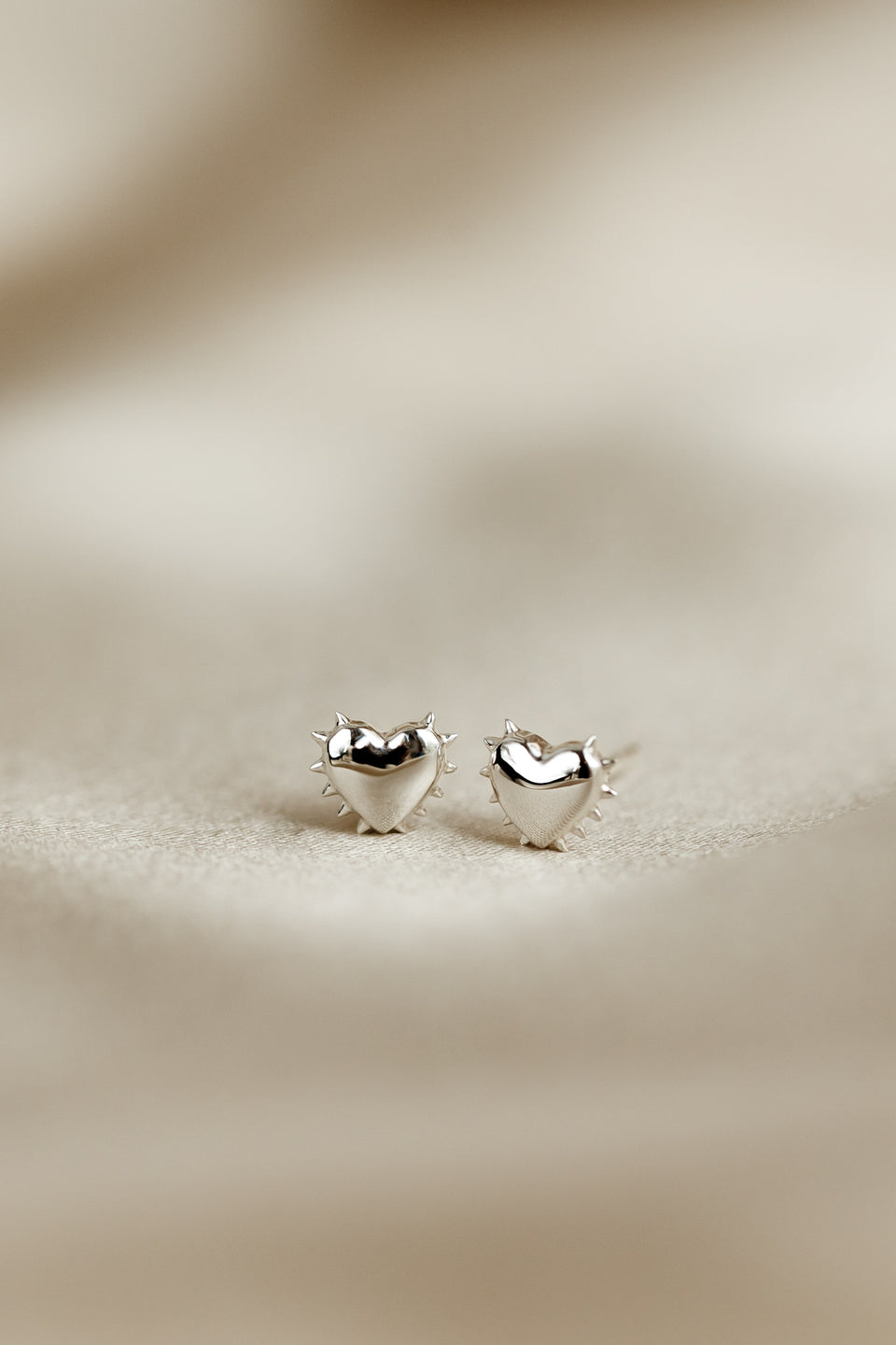A close-up image of the silver True Love Spike Heart Studs, detailing their heart shape and the small spikes around the edges.