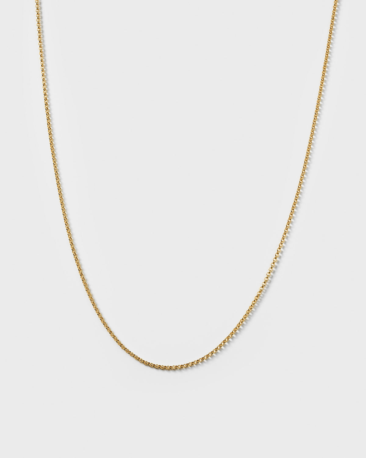 A product shot of the Beloved Medium Rolo Chain in gold, displayed in a soft curve to highlight its delicate rolo link design.