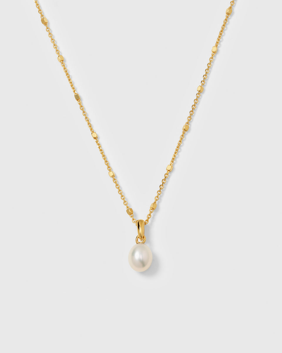 A product shot of the Treasure Single Pearl Necklace in gold, highlighting its unique chain and its single teardrop-shaped freshwater pearl pendant.
