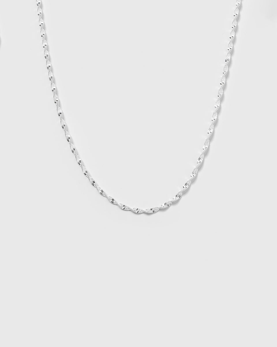 A product shot of the Herringbone Twisted Necklace in silver, detailing its shimmering and intricate twisted chain design.
