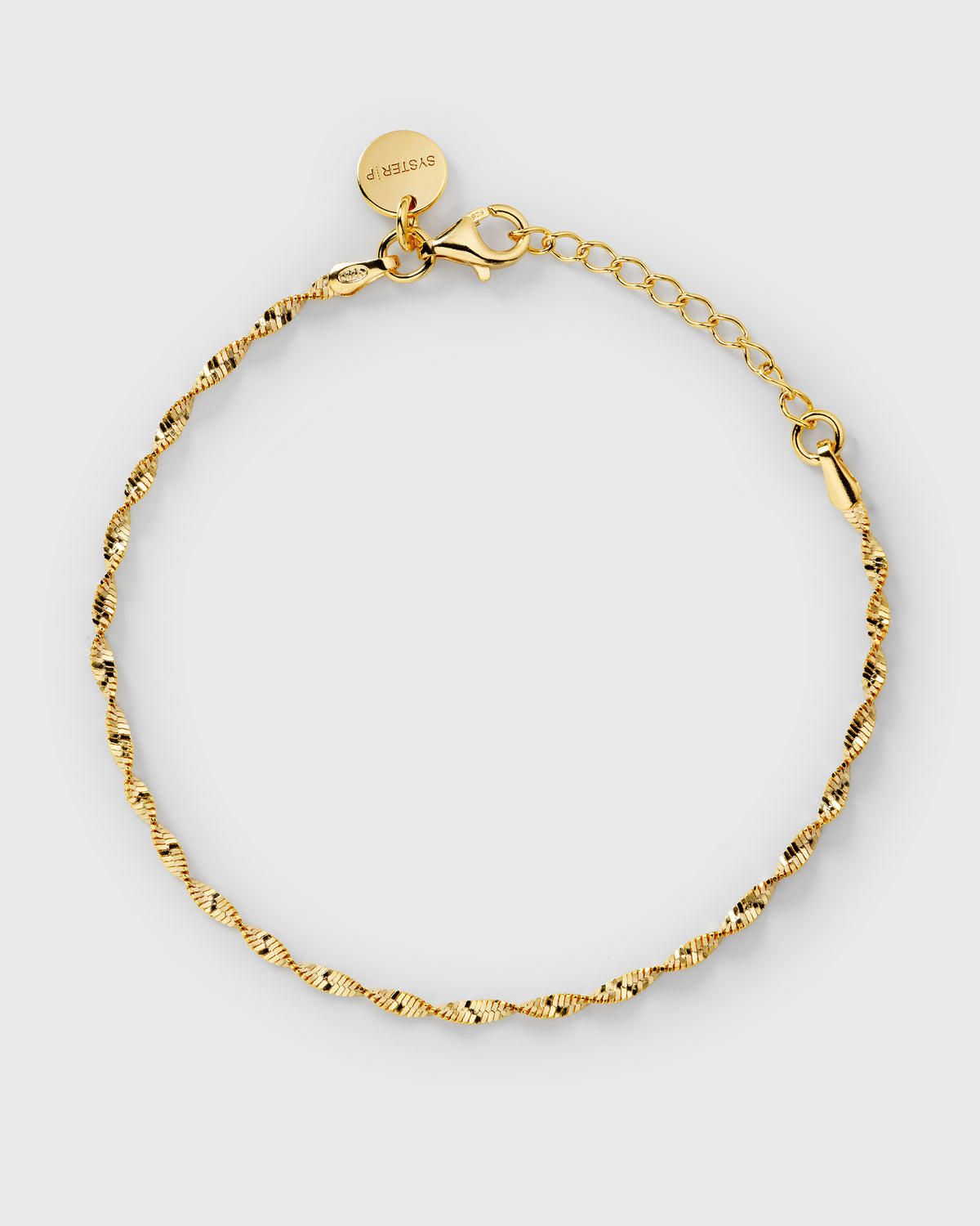 A product shot of the Herringbone Twisted Bracelet in gold, laid out in a circle to display its delicate twisted design.