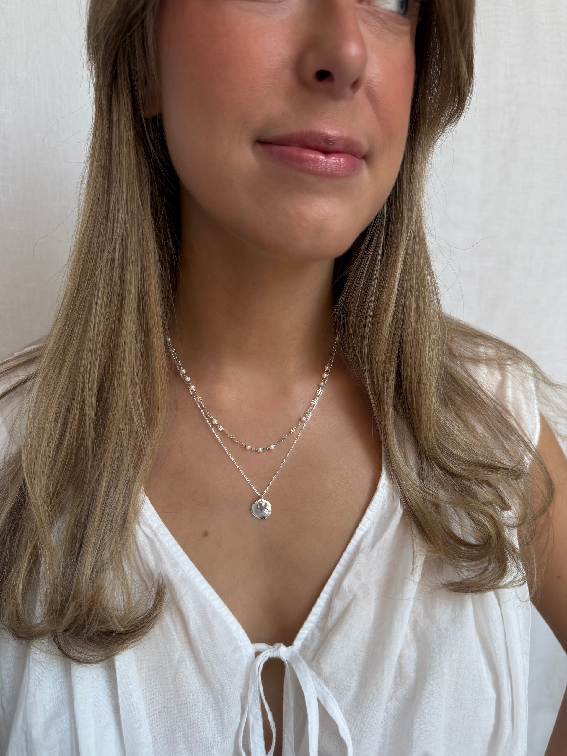 Short pearl necklace with a long charm necklace in sterling silver. 