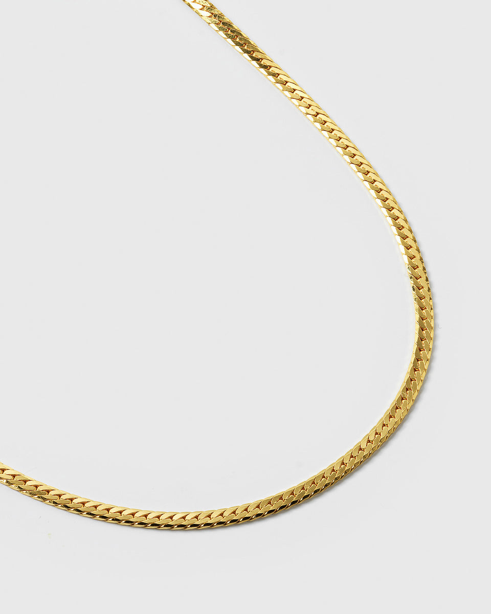 A close-up product shot of the Herringbone Bracelet in gold, highlighting the intricate and smooth design of its flat chain.