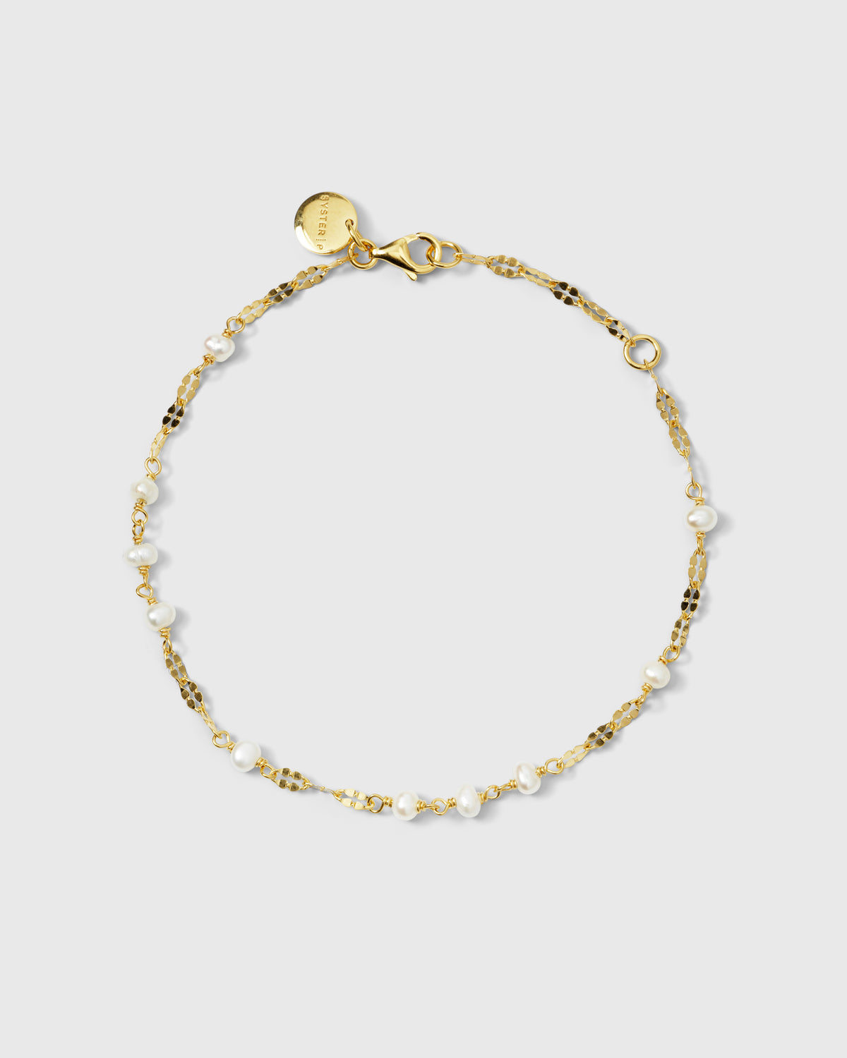 A product shot of the Aurelia Bracelet in gold, laid out in a circle to display its unique shimmering chain and interspersed freshwater pearls.
