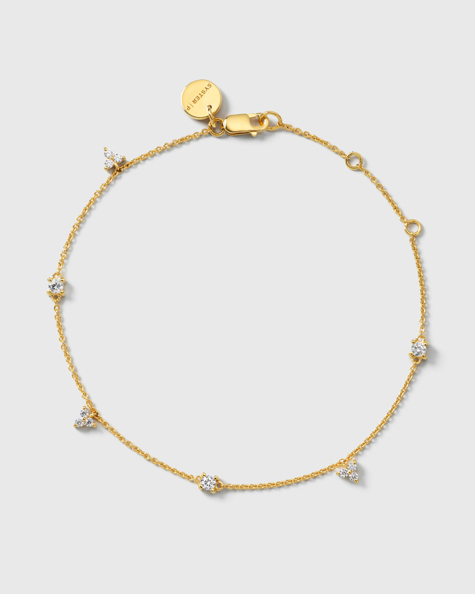 A product shot of the Celestia Bracelet in gold, laid out in a circle to display its delicate chain adorned with sparkling cubic zirconia stones.