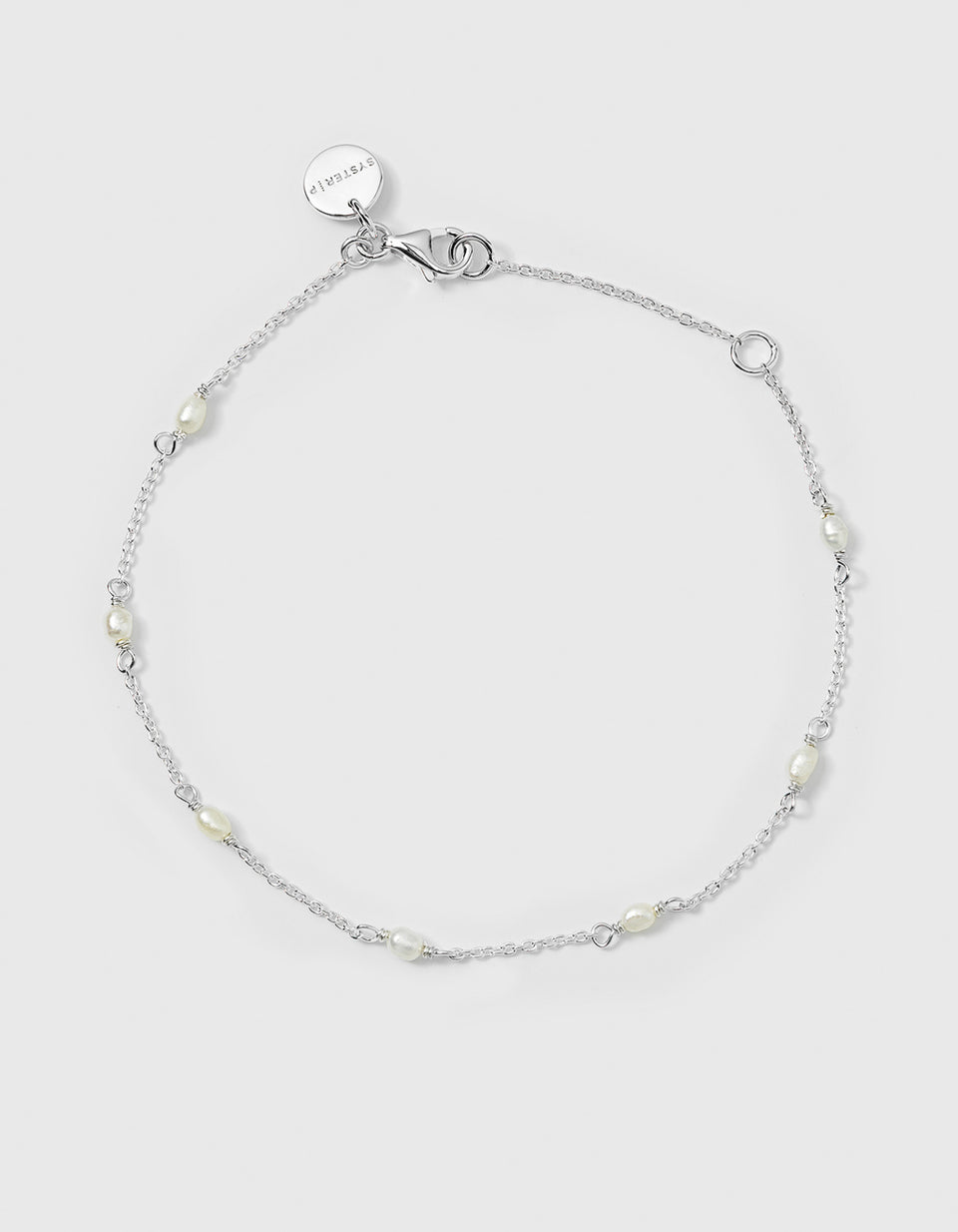 A product shot of the Treasure Multi Pearl Bracelet in silver, laid out in a circle to showcase its fine chain decorated with small freshwater pearls spaced throughout.
