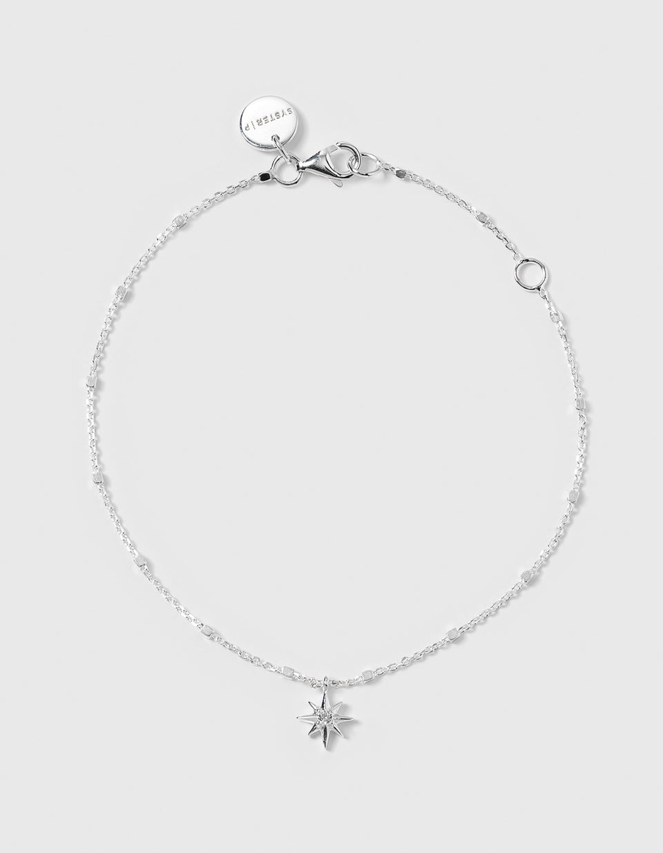 A product shot of the North Star Bracelet in silver, laid out to showcase its delicate chain and a North Star charm set with a sparkling crystal.