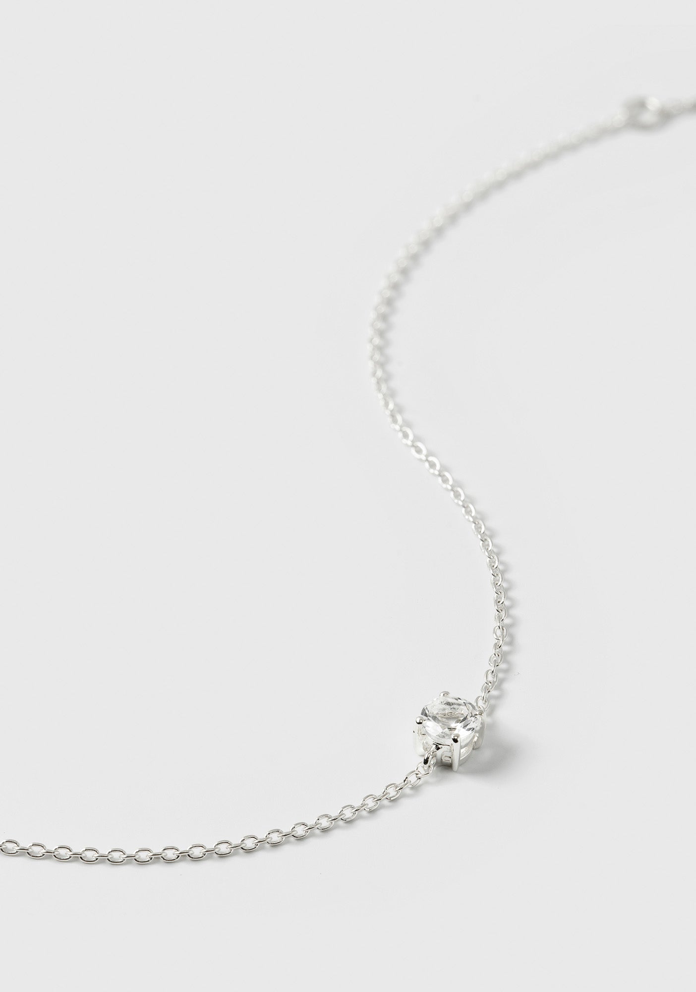 A close-up shot of the Minimalistica Solo Nova Bracelet in silver, highlighting its delicate chain and the single white topaz stone.