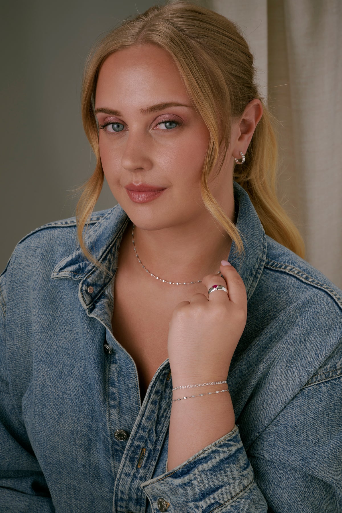 A model wearing the Herringbone Twisted Bracelet in silver, stacked with Sheer Love Bracelet in silver