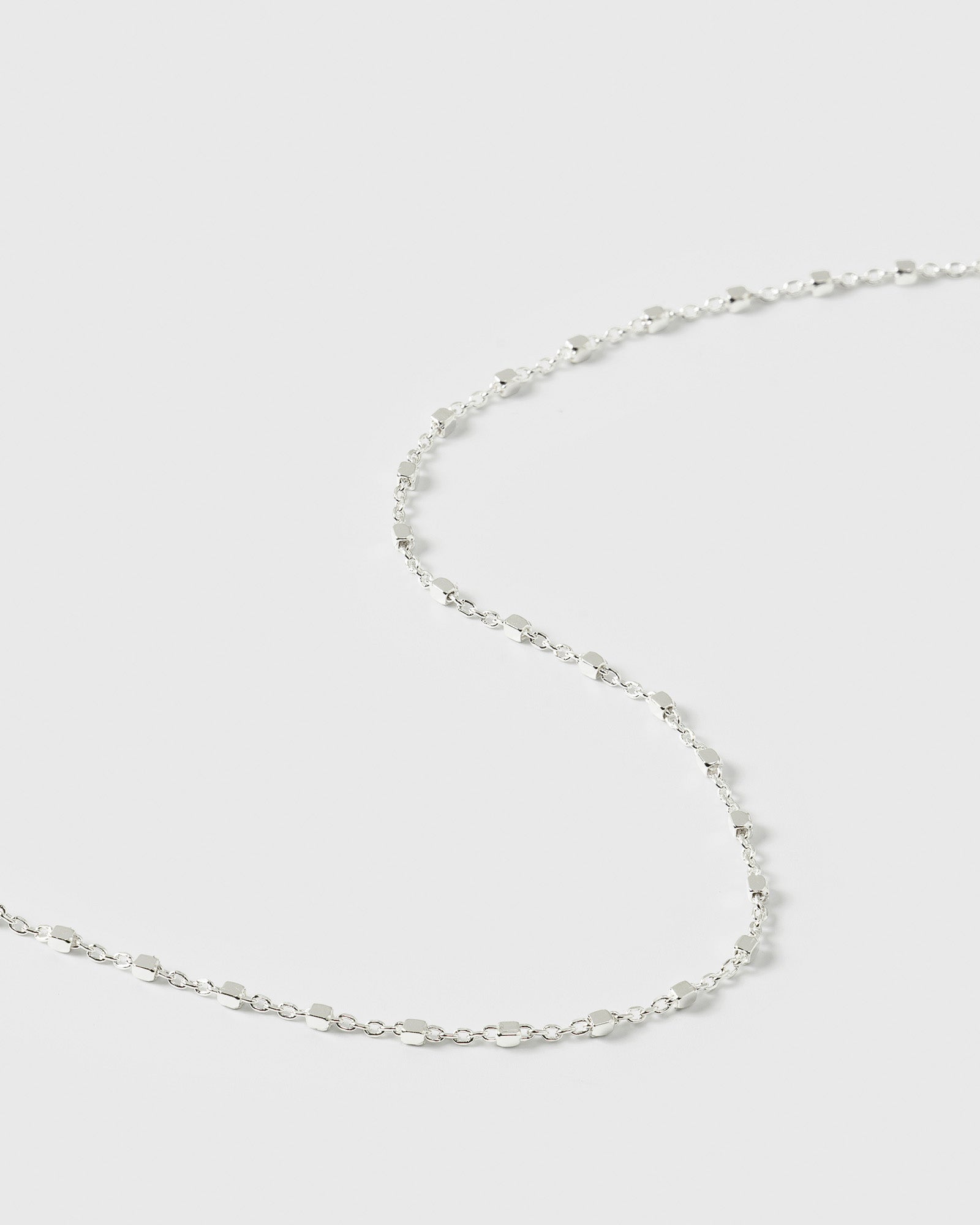 A close-up product shot of the Sheer Station Bracelet in silver, highlighting its delicate design of a fine chain with small, evenly spaced cube-shaped beads.