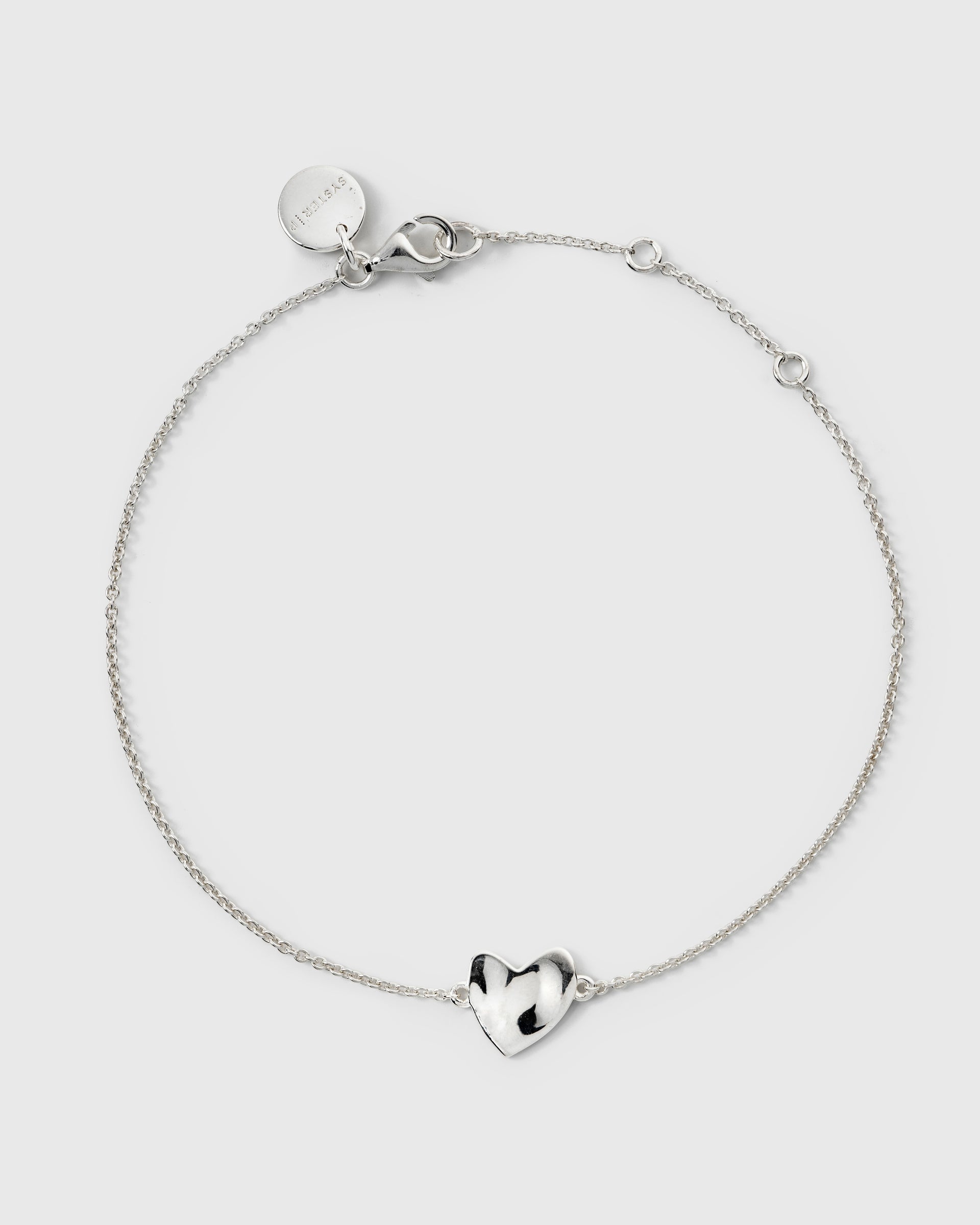 Delicate silver chain bracelet featuring a hammered heart charm.