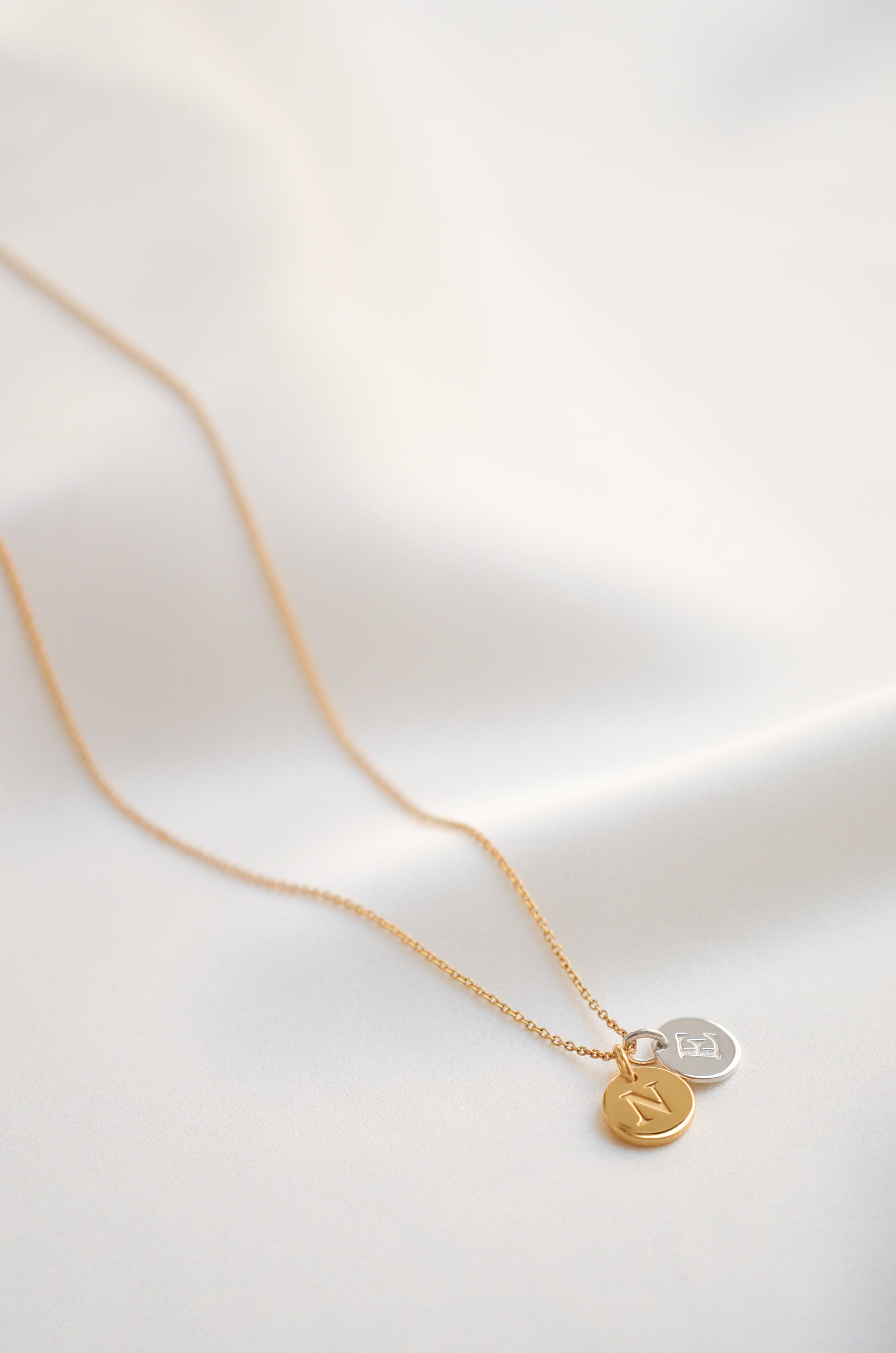 One gold chain with one gold mini letter and one silver mini letter
