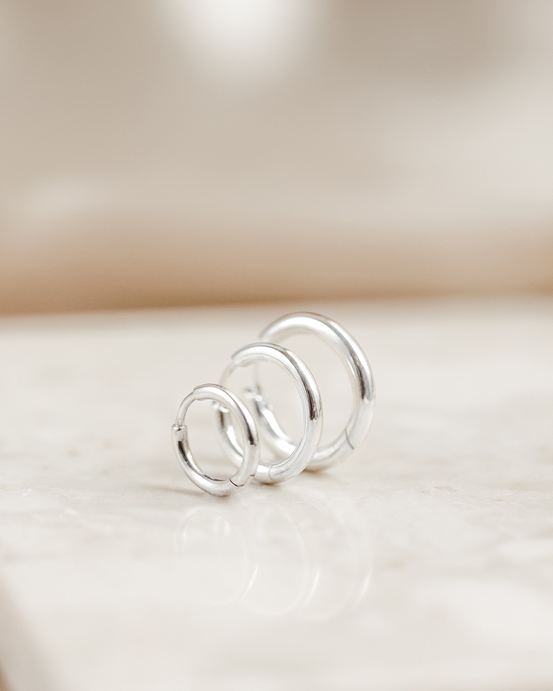 A product shot of the Beloved Fat Hoops Set in silver, showcasing the three chunky hoops in small, medium, and large sizes arranged in a row.