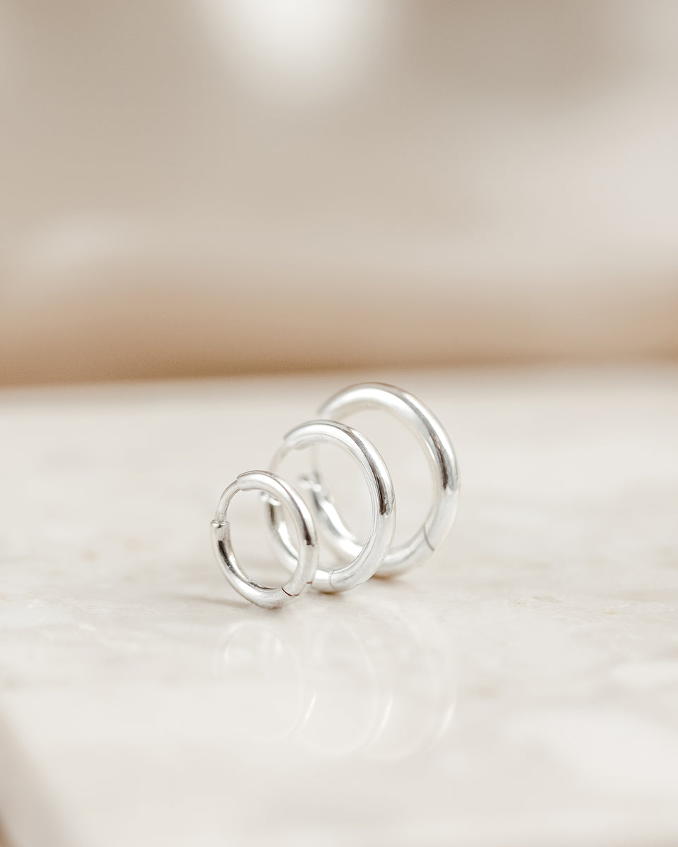 A product shot of the Beloved Fat Hoops Set in silver, showcasing the three chunky hoops in small, medium, and large sizes arranged in a row.