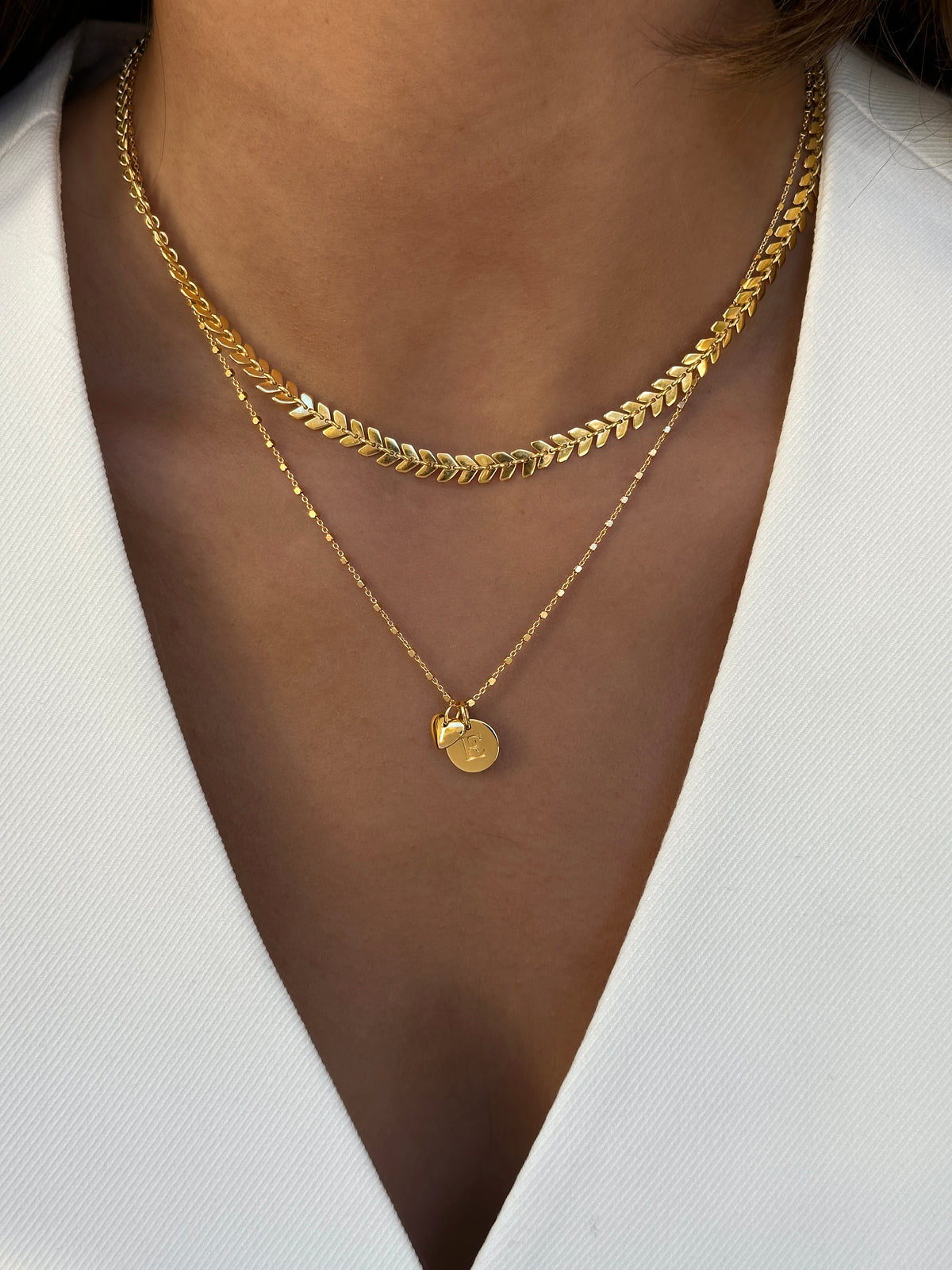Modell som b‚àö¬ßr tv‚àö‚Ä¢ guld halsband med tv‚àö‚Ä¢ berlocker. 