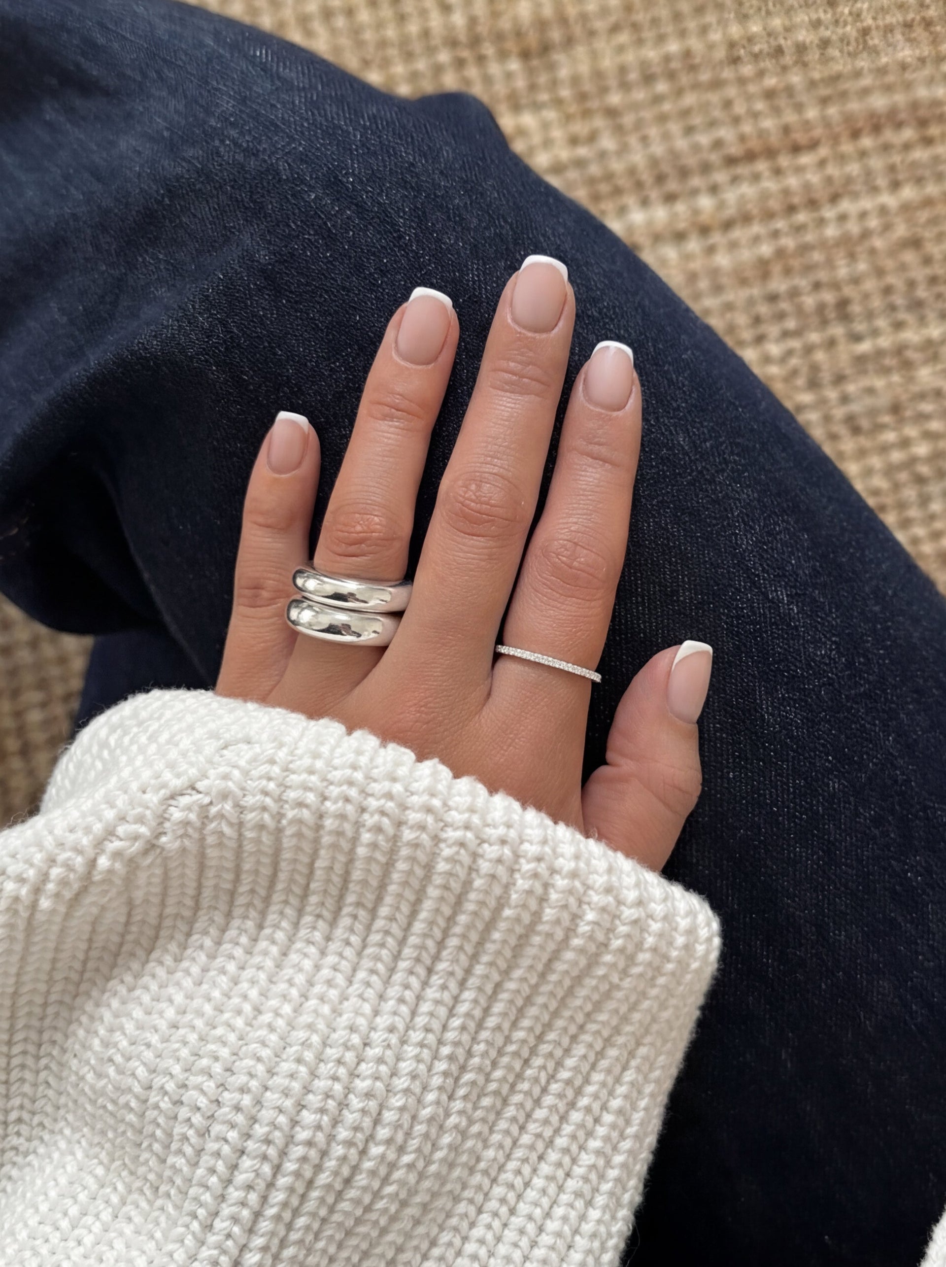 A close-up shot of a model wearing the Bolded Ring in silver, highlighting its substantial and rounded double-band design.