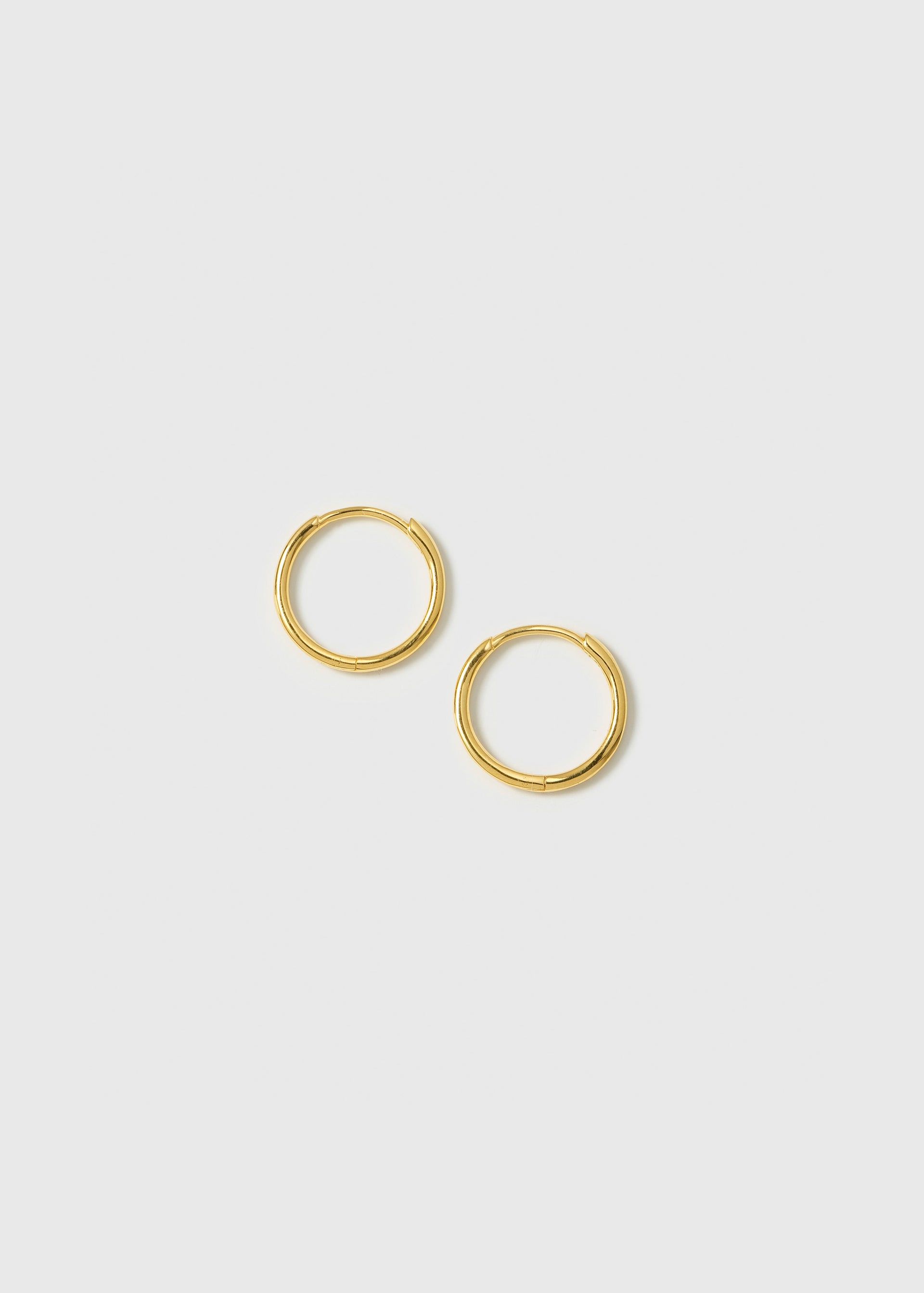 A product shot of the Beloved Small Hoops in gold, showcasing their simple and classic design.