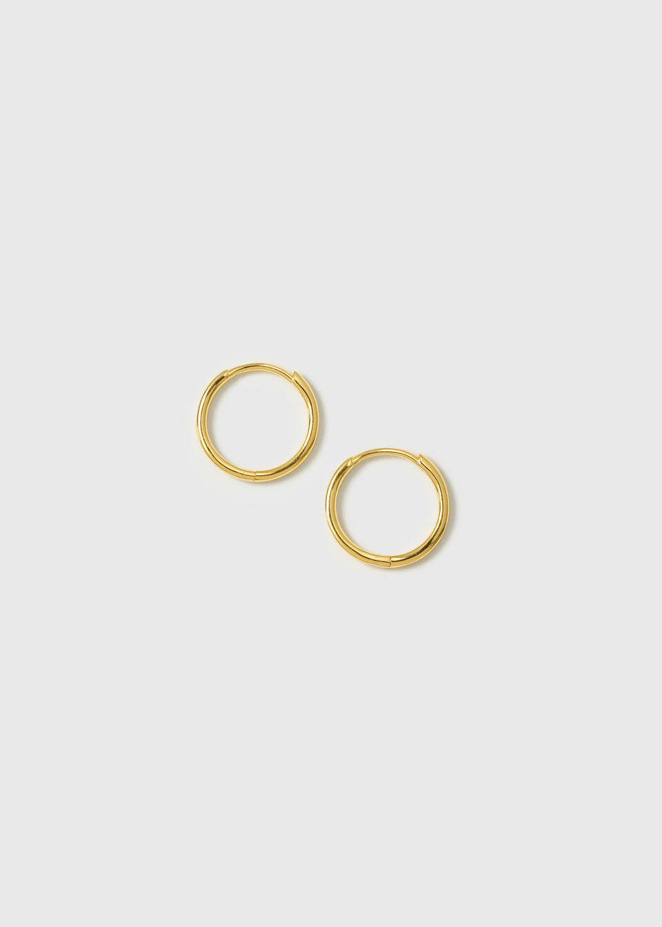 A product shot of the Beloved Small Hoops in gold, showcasing their simple and classic design.