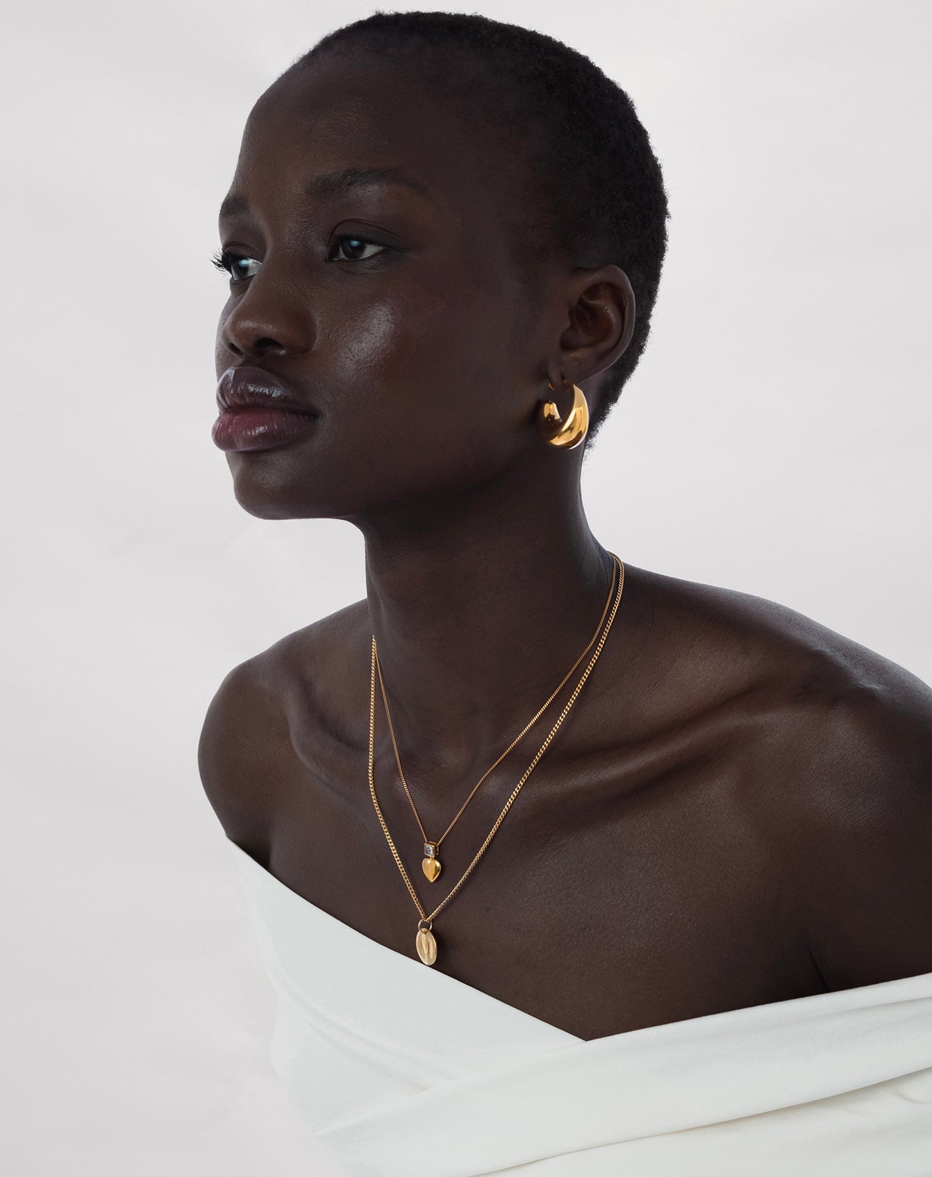 Modell som har på sig Bolded Earrings och två halsband.