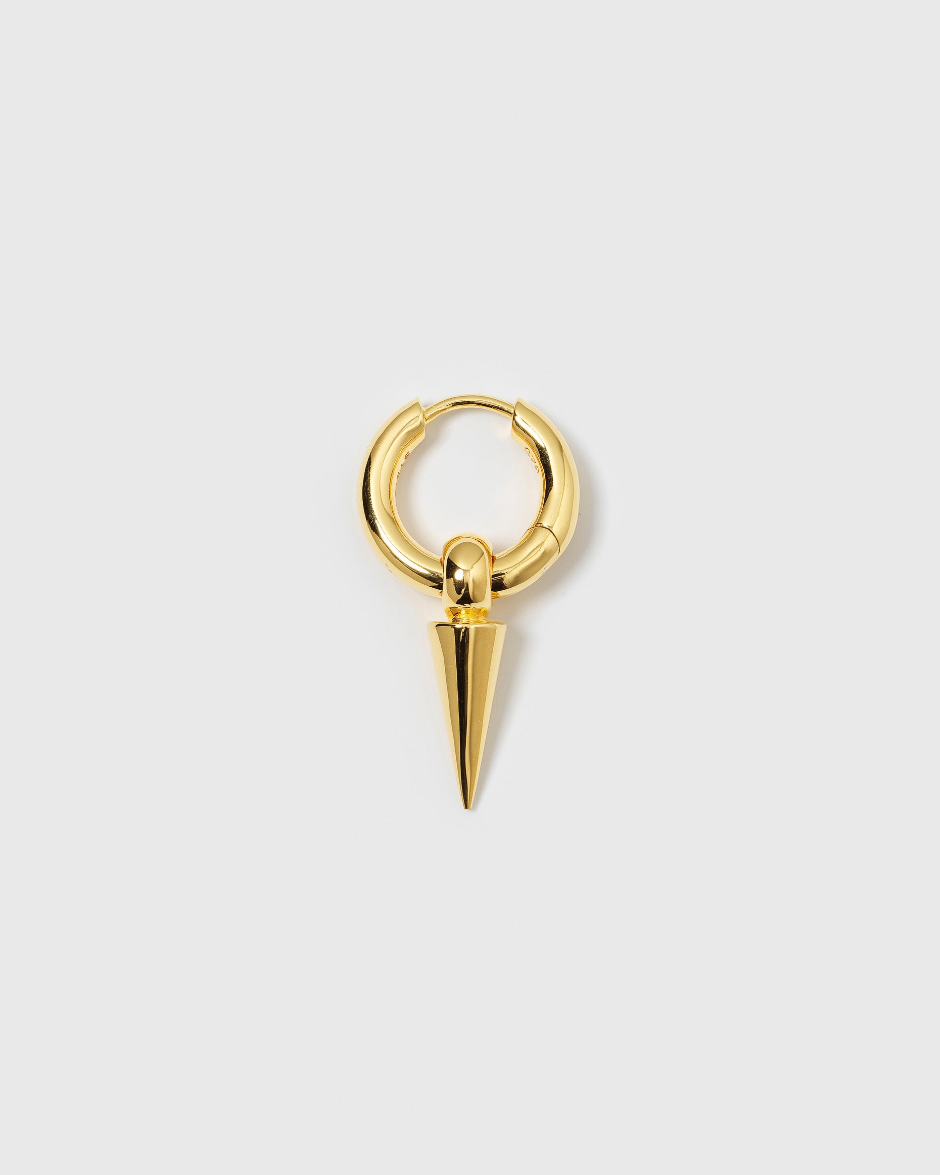 A product shot of the Juno Single Hoop in gold, featuring a thick hoop with a dangling spike charm.
