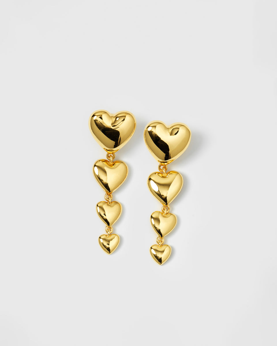 A product shot of the Darling Earrings in gold, featuring a design of four cascading bold hearts that form a long pendant.
