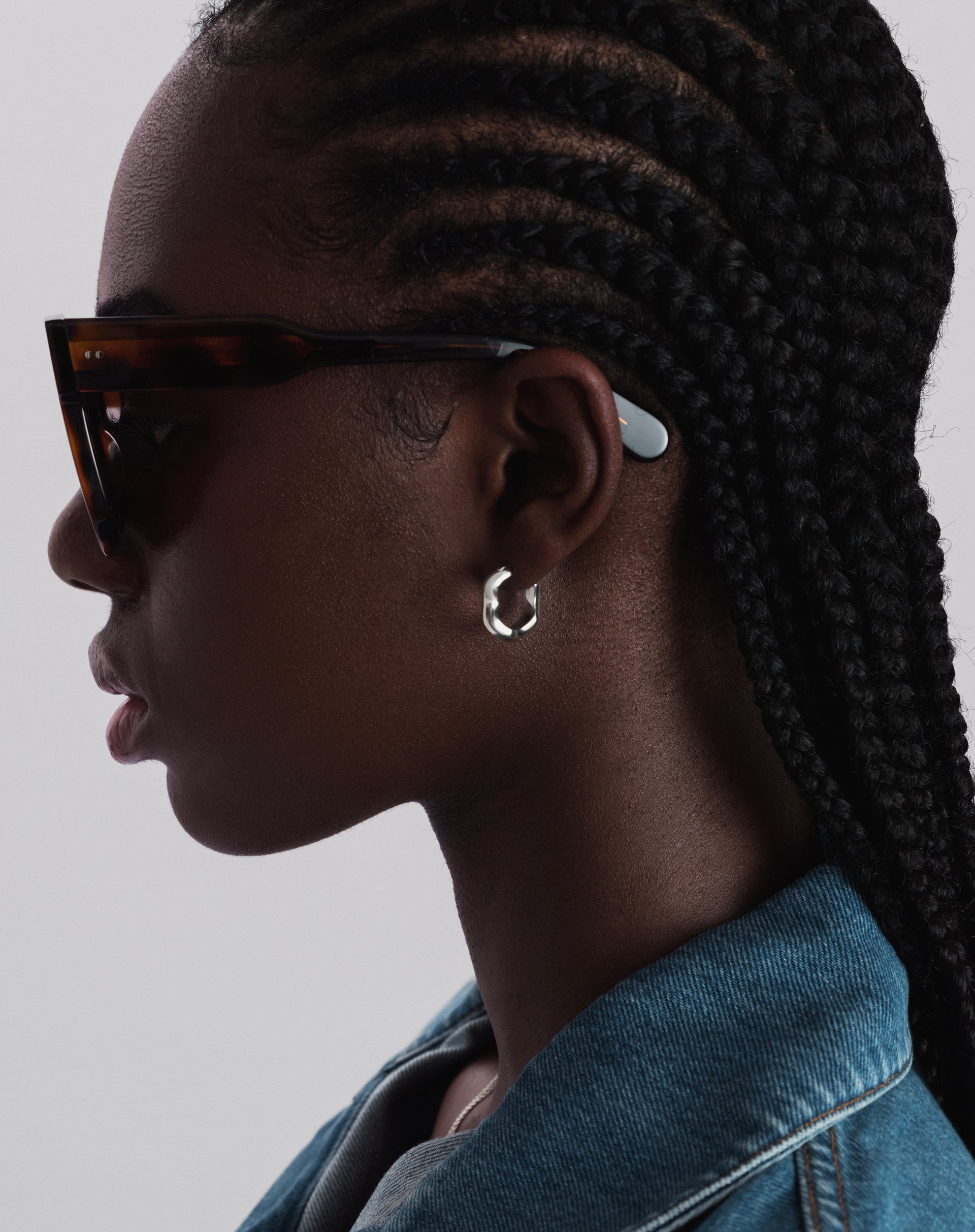 A close-up shot of a model wearing the Bolded Wavy Earrings in silver, highlighting their unique wavy design.