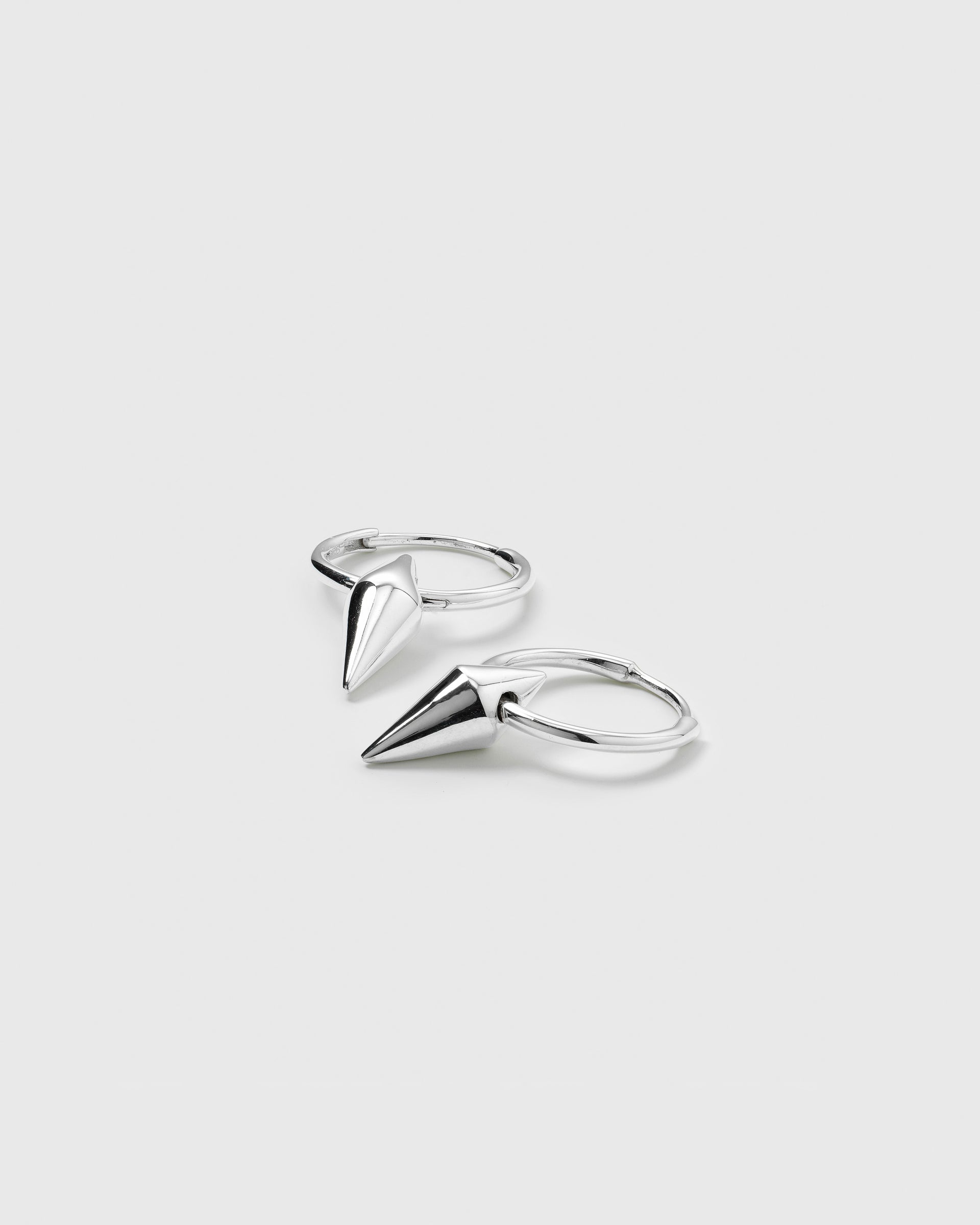 A product shot of the Harvey Small Spike Hoops in silver, showing the pair of small hoop earrings, each with a dangling cone-shaped spike charm.
