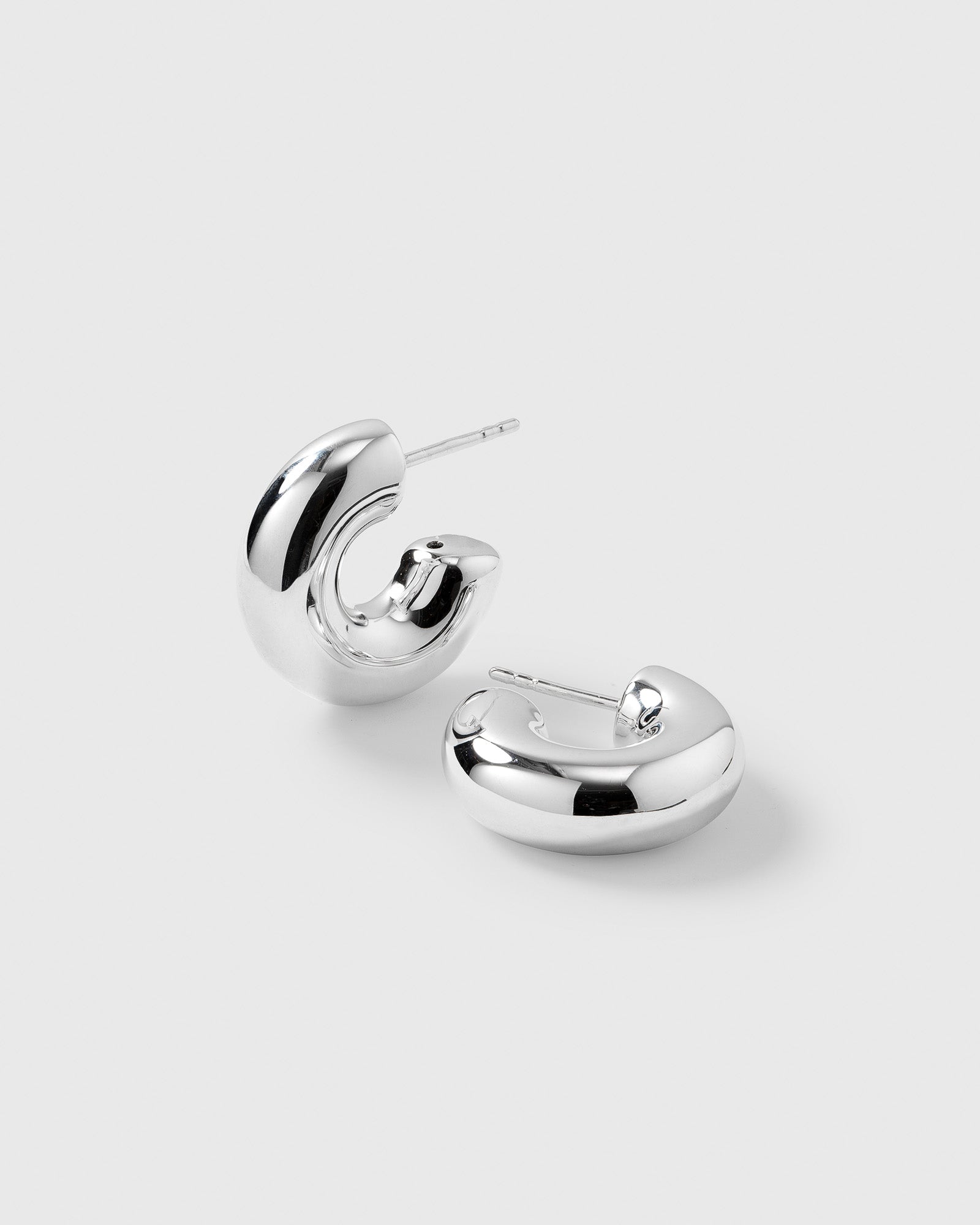 A product shot of the Bolded Little Sis Hoops in silver, showcasing the pair's chunky, rounded, and polished design.