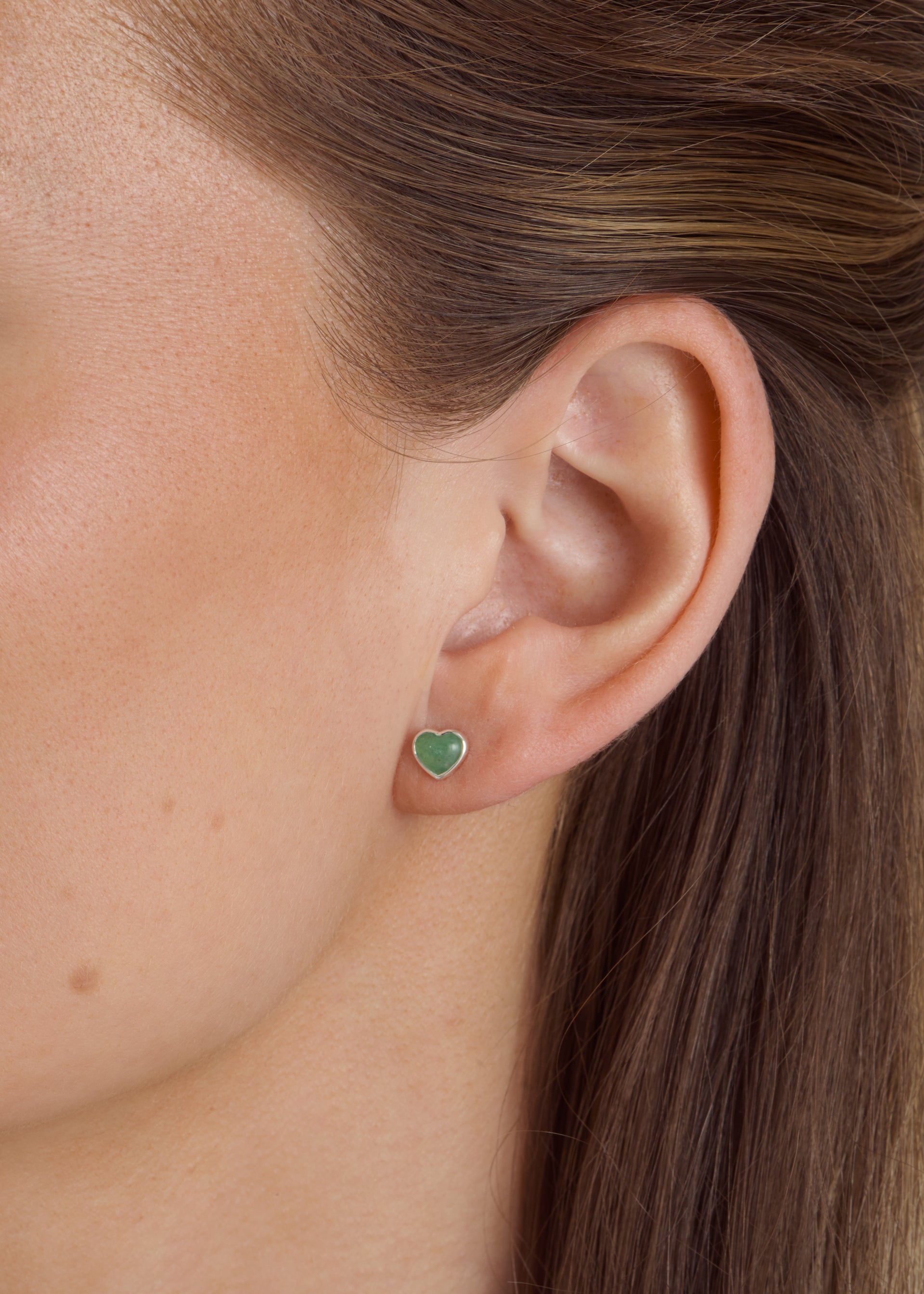 Close-up of a model wearing the silver La La Love stud earring with a heart-shaped green jade stone and silver frame.