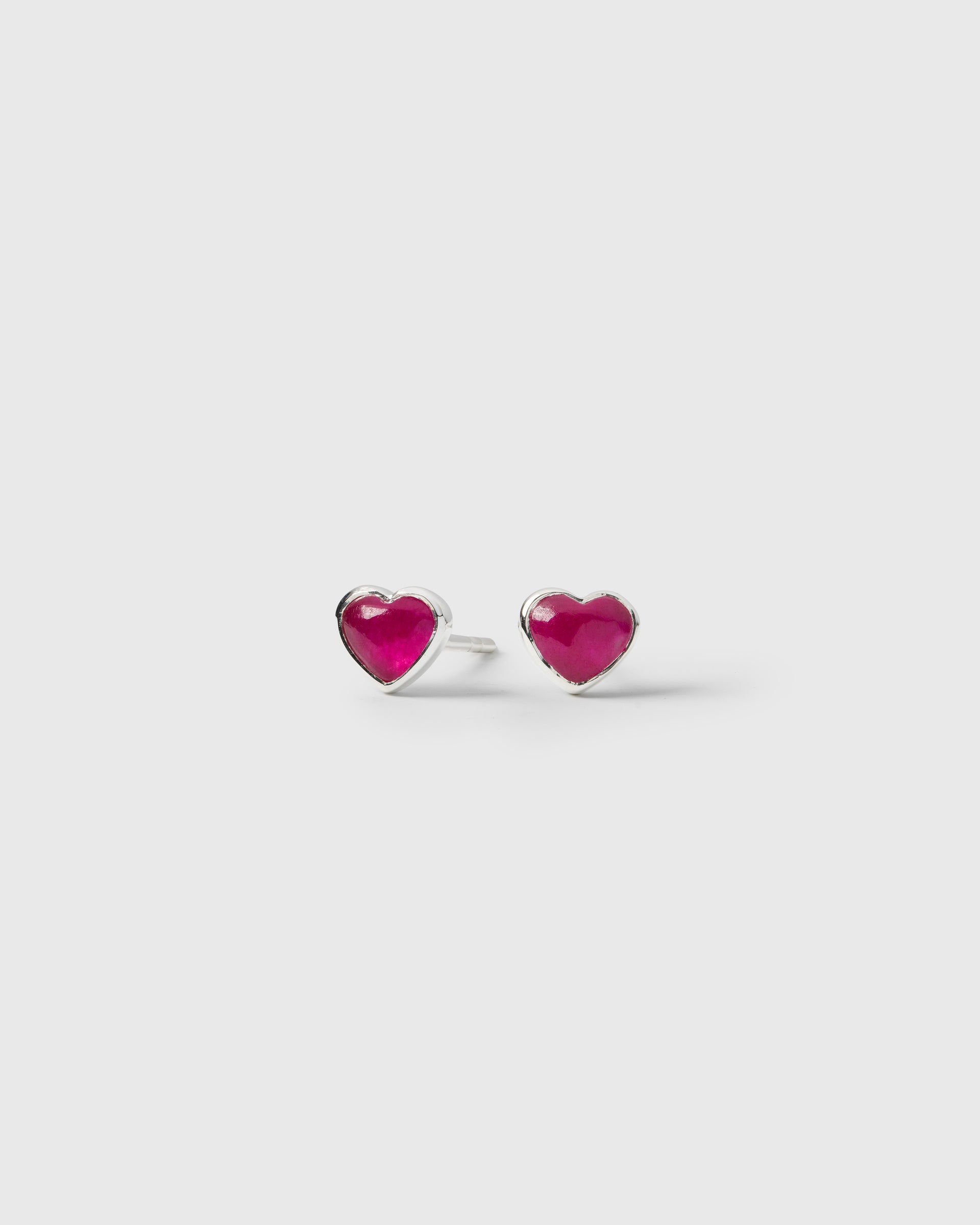 A pair of La La Love stud earrings in silver, a heart-shaped design featuring a pink quartz stone set in sterling silver.