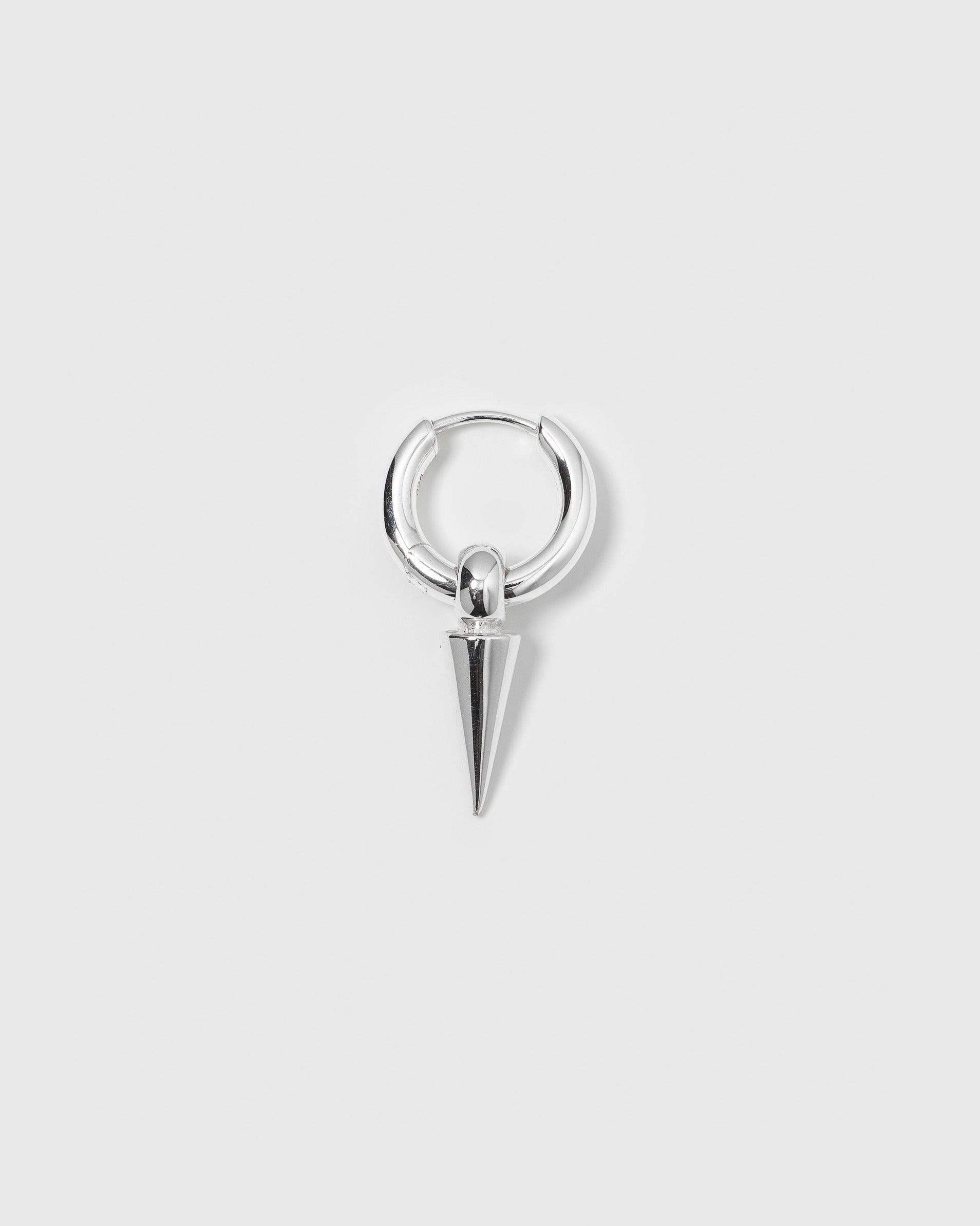 A product shot of the Juno Single Hoop in silver, featuring a dangling spike charm.