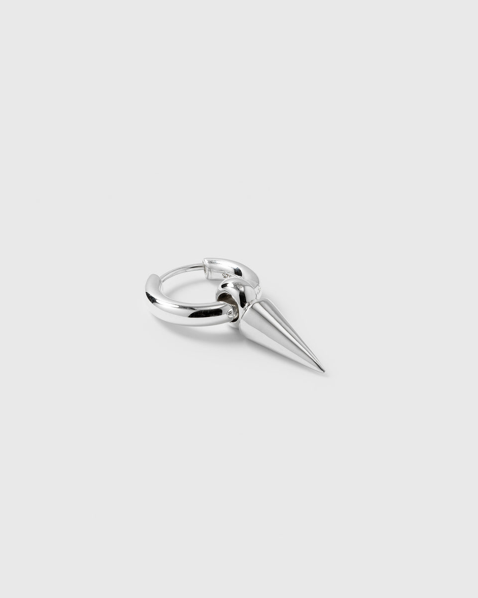A product shot of the Juno Single Hoop in silver, featuring a small hoop with a dangling spike pendant.