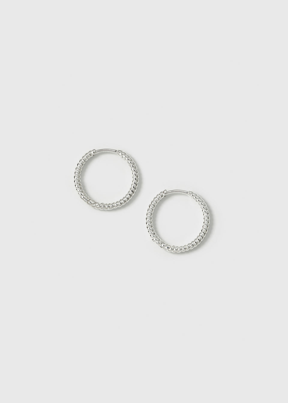 A product shot of the Beloved Twisted Medium Hoops in silver, showcasing their unique twisted design.