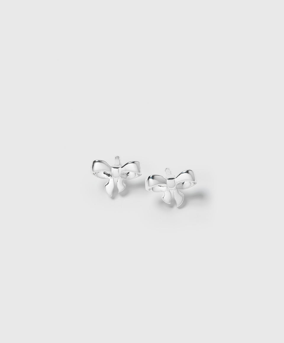 A product shot of the Rosie Mini Studs in silver, showcasing the pair of delicate, bow-shaped earrings.