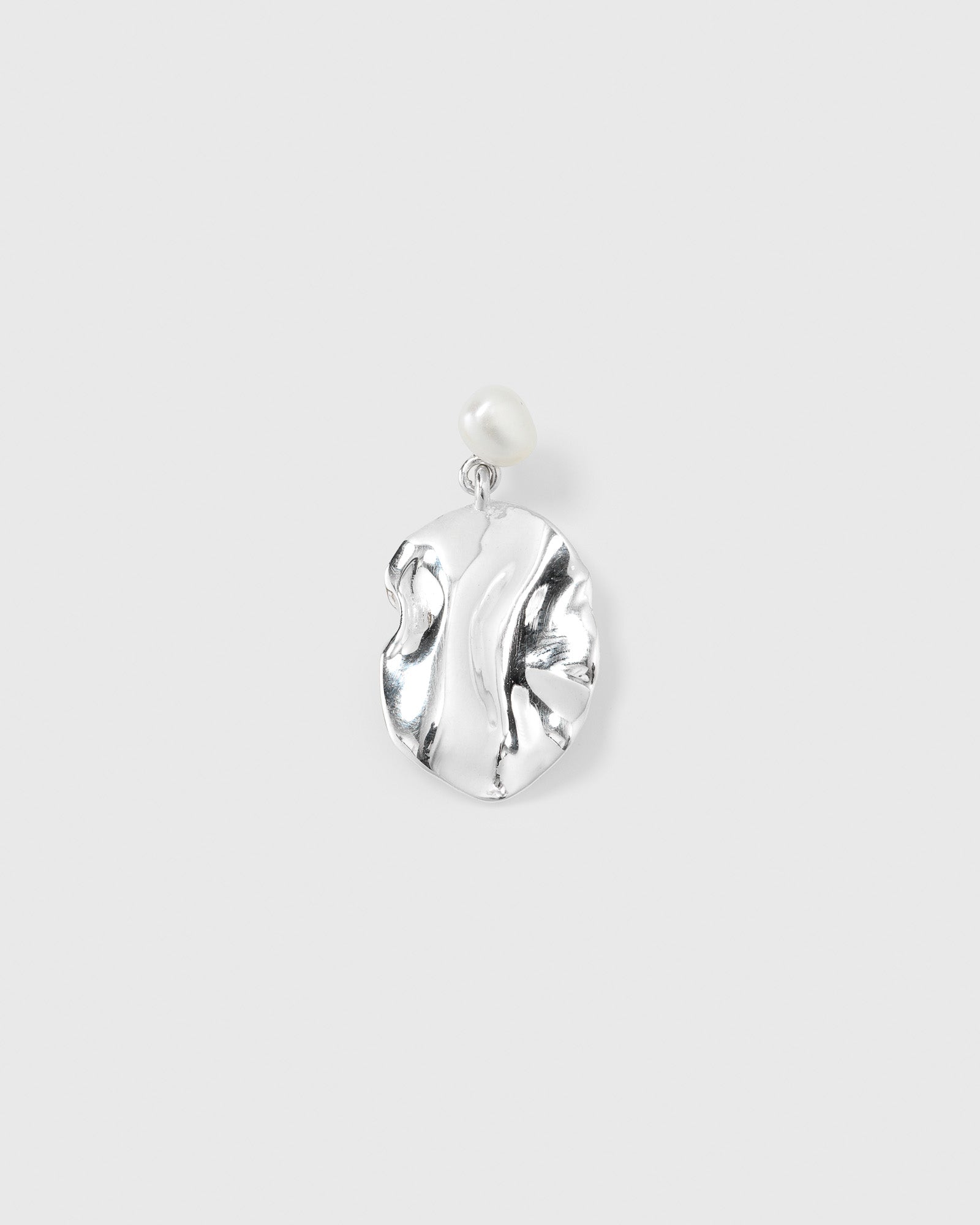 A product shot of the Moulded Short Single Earring in silver, highlighting its textured, irregularly shaped pendant topped with a single freshwater pearl.