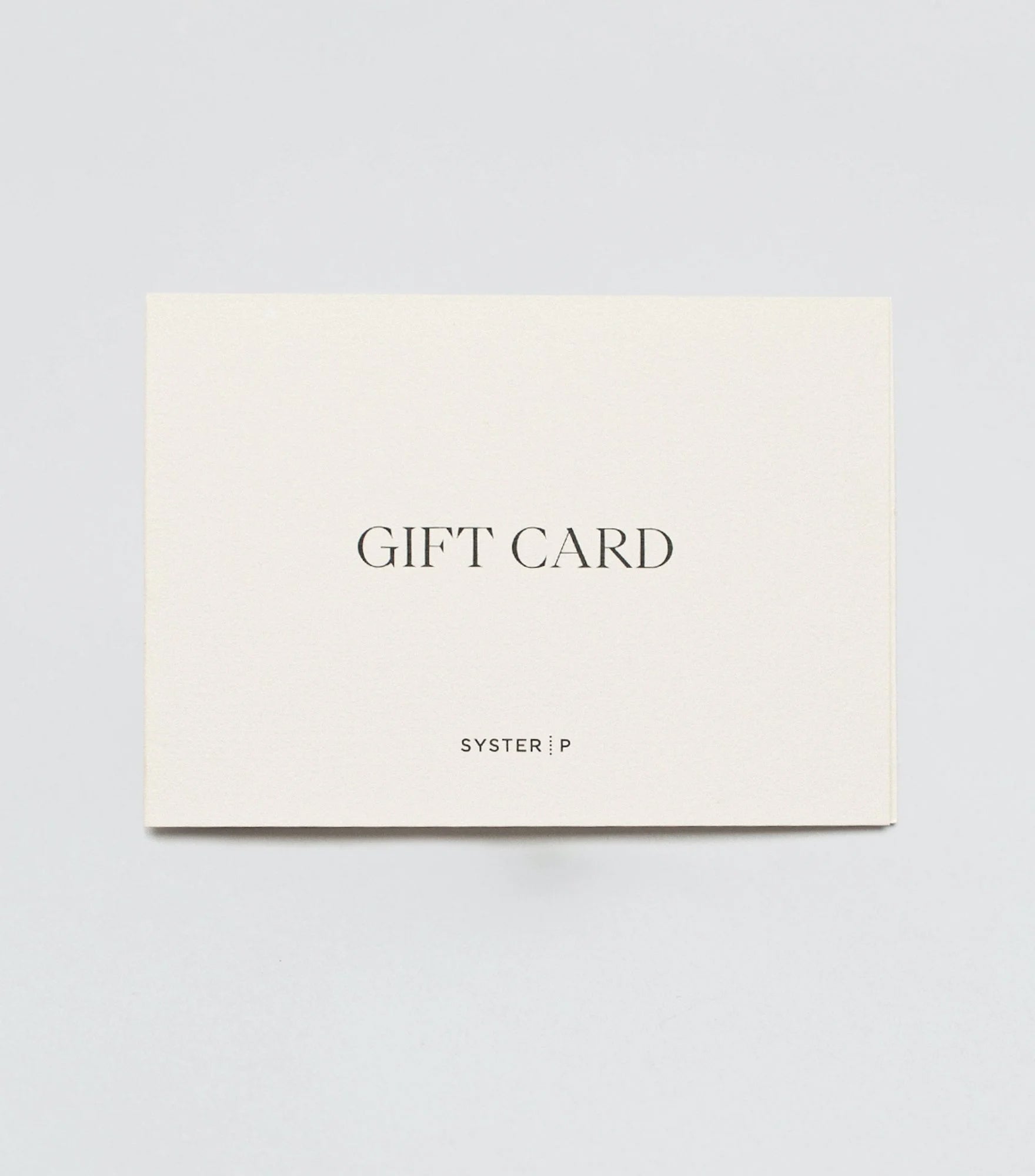 A product shot of the Syster P gift card, a rectangular cream-colored card with 'GIFT CARD' and the brand's logo printed on the front in black text.