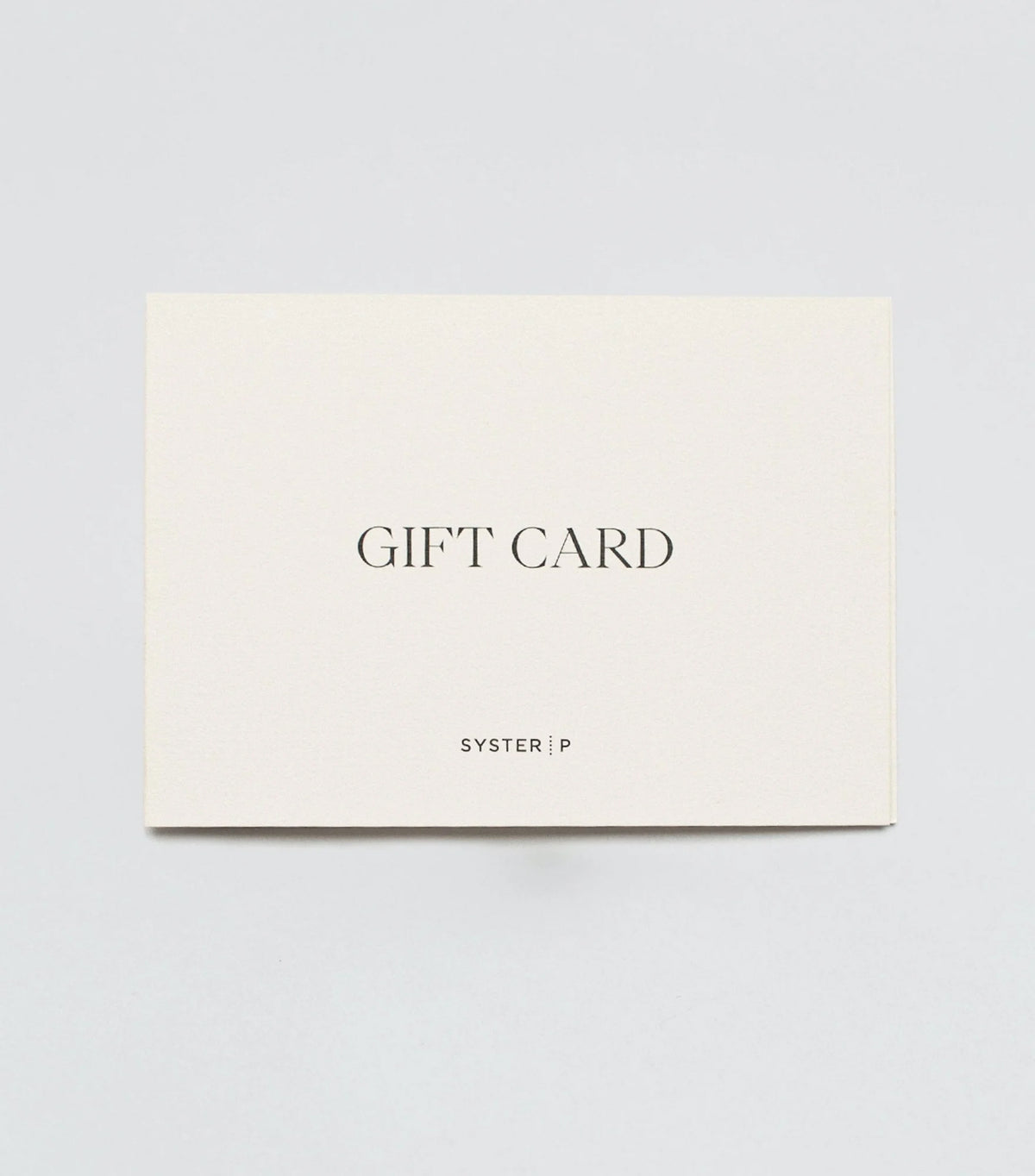 A product shot of the Syster P gift card, a cream-colored card with "GIFT CARD" and the Syster P logo printed on the front.