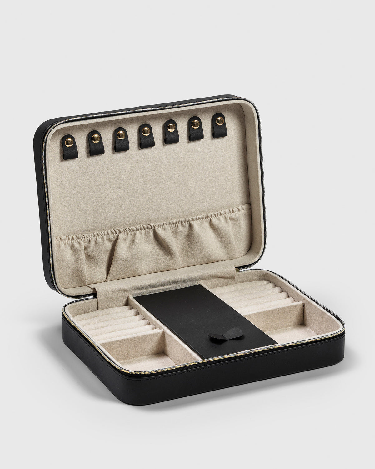 A product shot of the Jewelry Case Large in black, opened to display its beige microfiber interior with various compartments designed for organizing rings, necklaces, bracelets, and earrings.