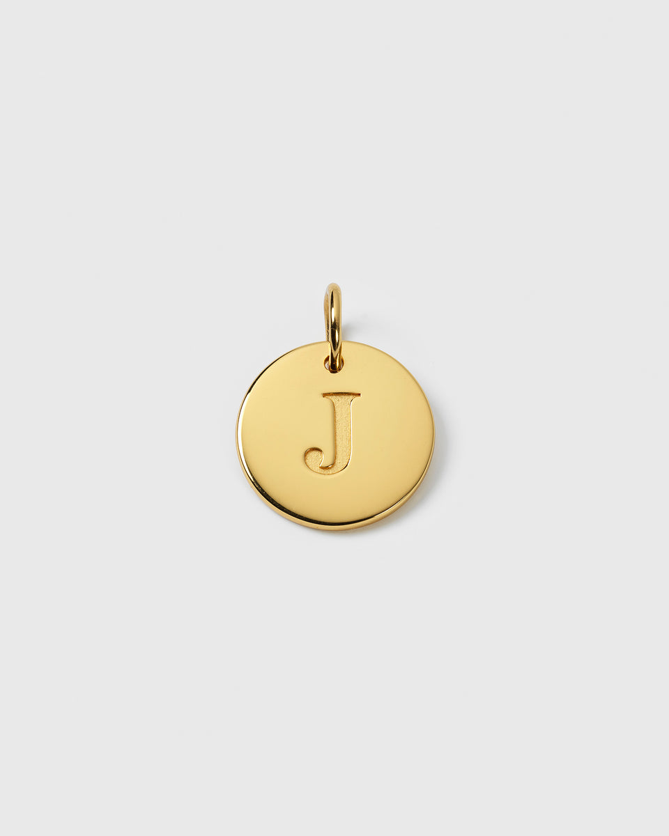 A product shot of the Beloved Big Letter Gold charm, a round gold-plated pendant with the letter 'J' engraved on its front.