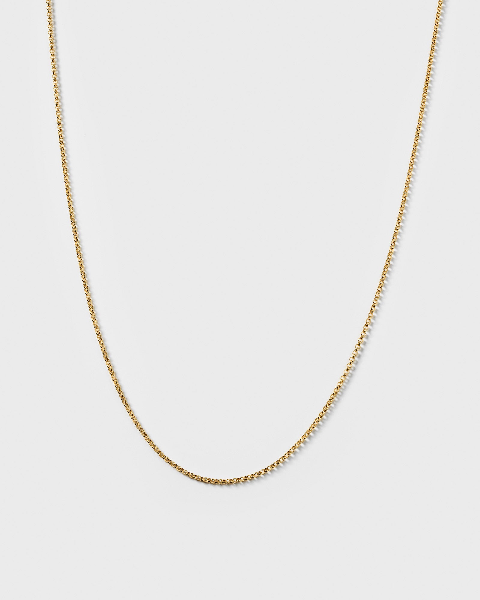 A product shot of the Beloved Medium Rolo Chain in gold, displayed in a soft curve to highlight its delicate rolo link design.