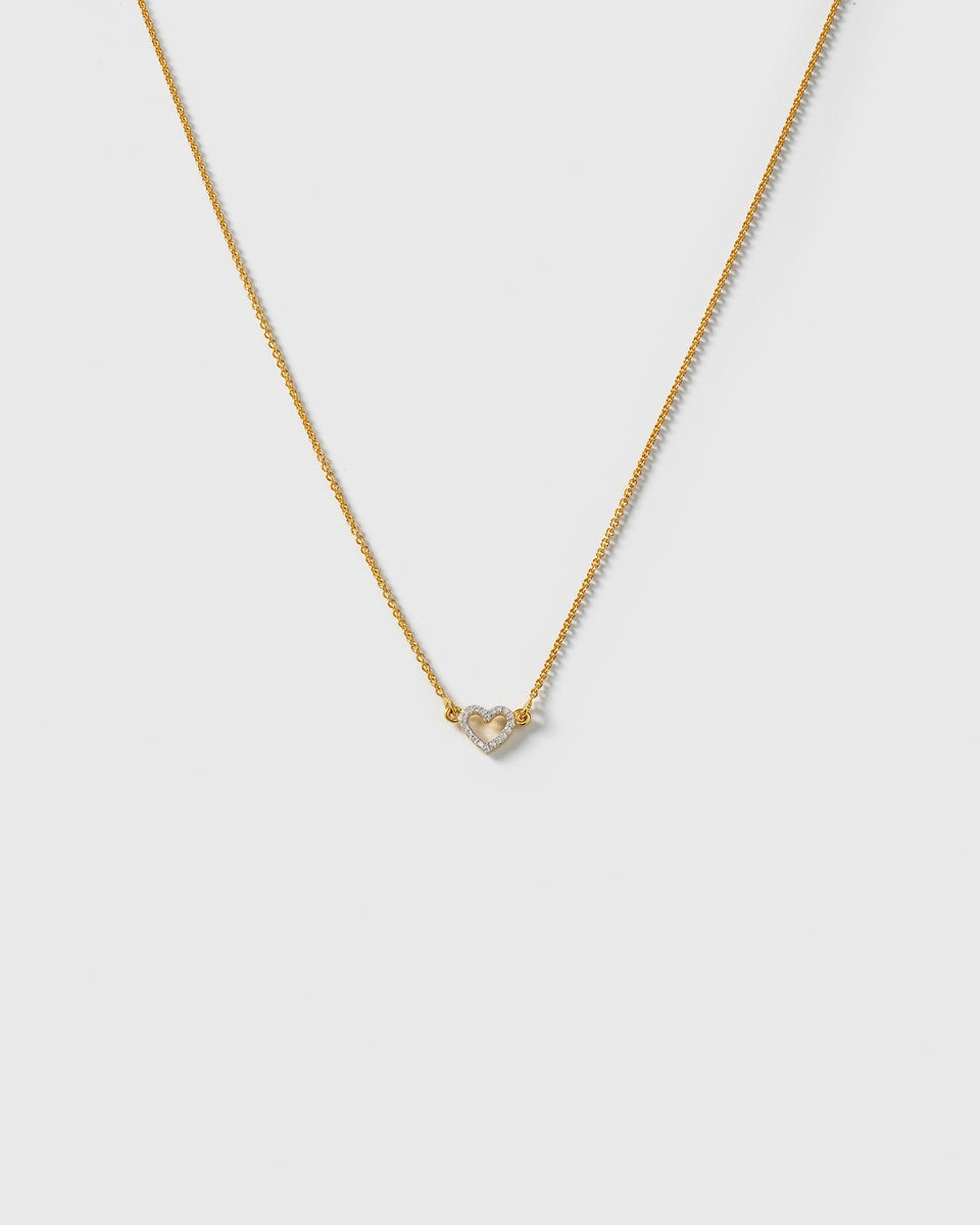 A product shot of the Snap Heart Necklace in gold, featuring a fine chain and a heart-shaped pendant covered in clear crystal stones.