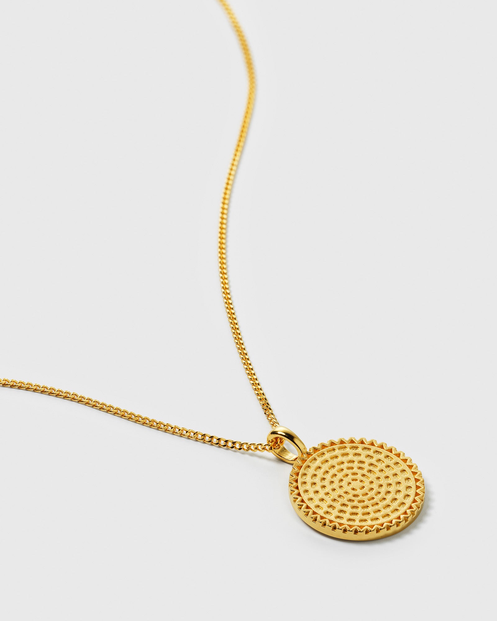 A close-up shot of the Lucky Coin Heal Necklace in gold, showcasing its round pendant with a detailed sun pattern on a fine chain.