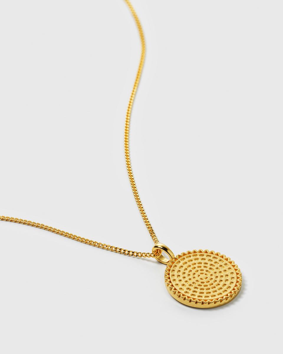 A close-up shot of the Lucky Coin Heal Necklace in gold, showcasing its round pendant with a detailed sun pattern on a fine chain.