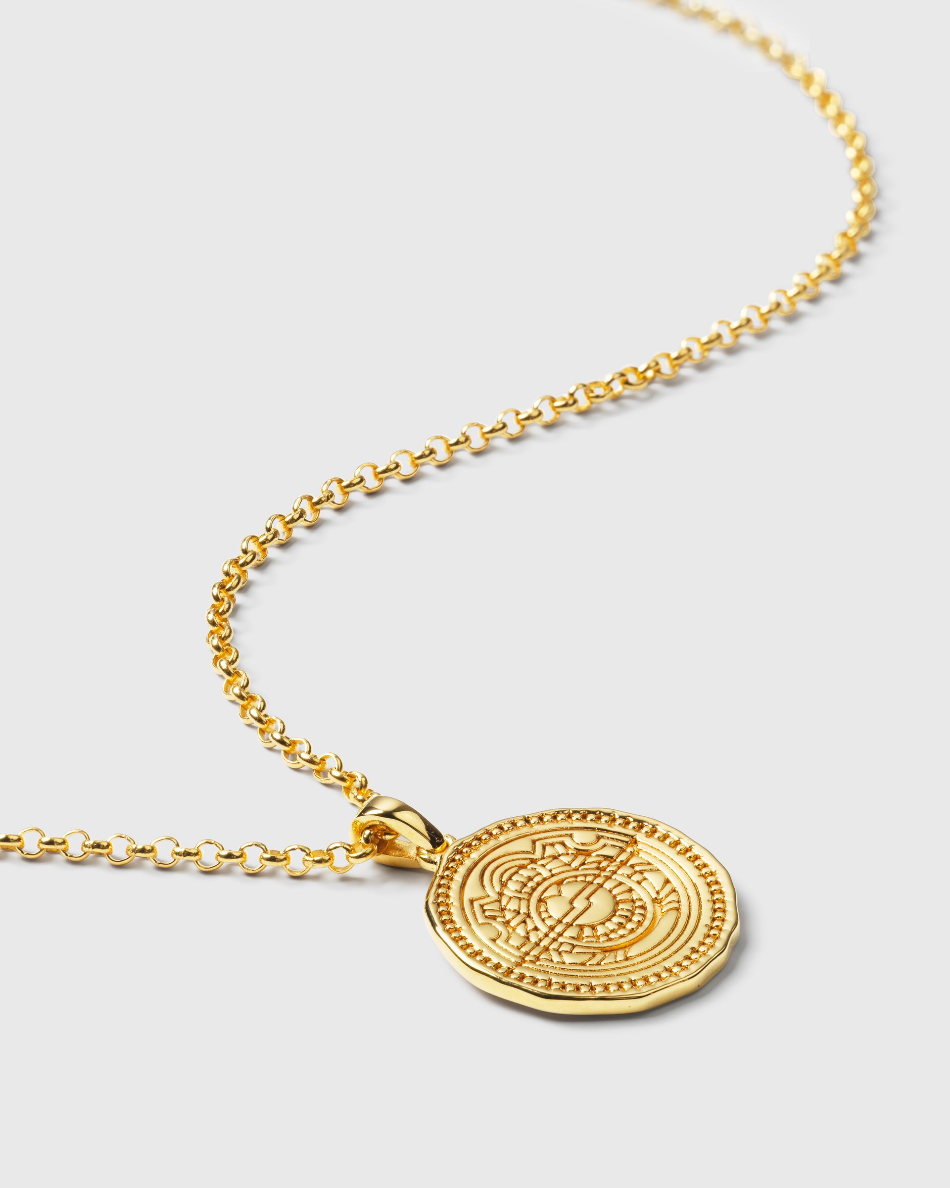 A product shot of the Lucky Coin Navigate Necklace in gold, displaying its delicate chain and round pendant featuring an intricate compass design.