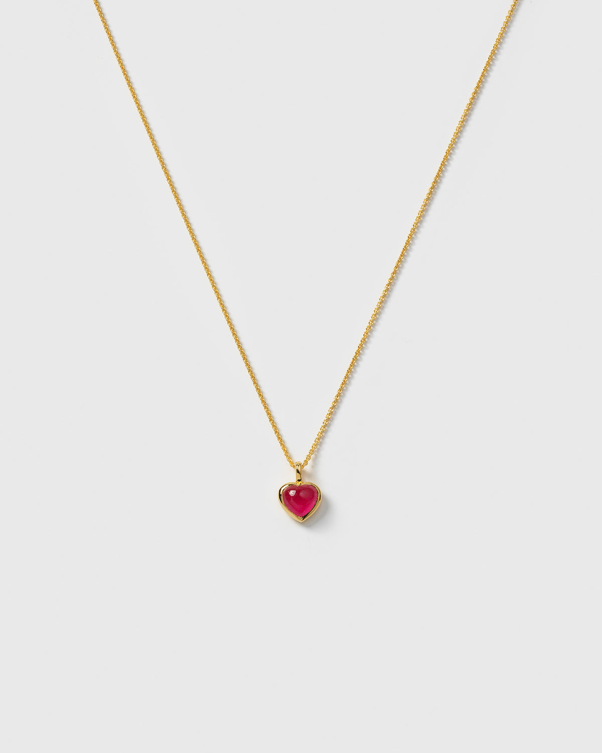 A product shot of the La La Love Necklace in gold, featuring a delicate chain and a heart-shaped pink quartz pendant.