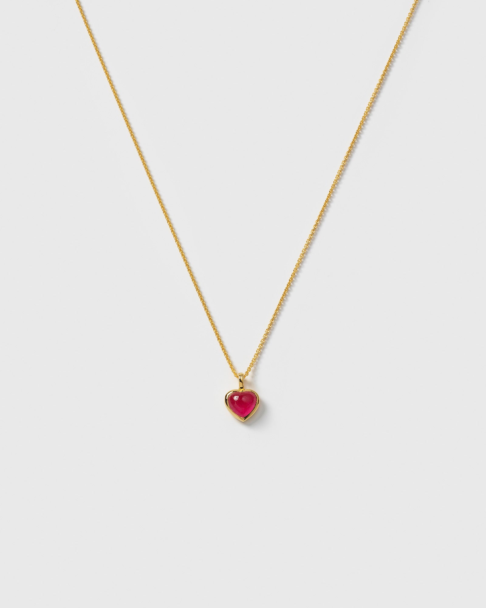 A product shot of the La La Love Necklace in gold, featuring a delicate chain and a heart-shaped pink quartz pendant.