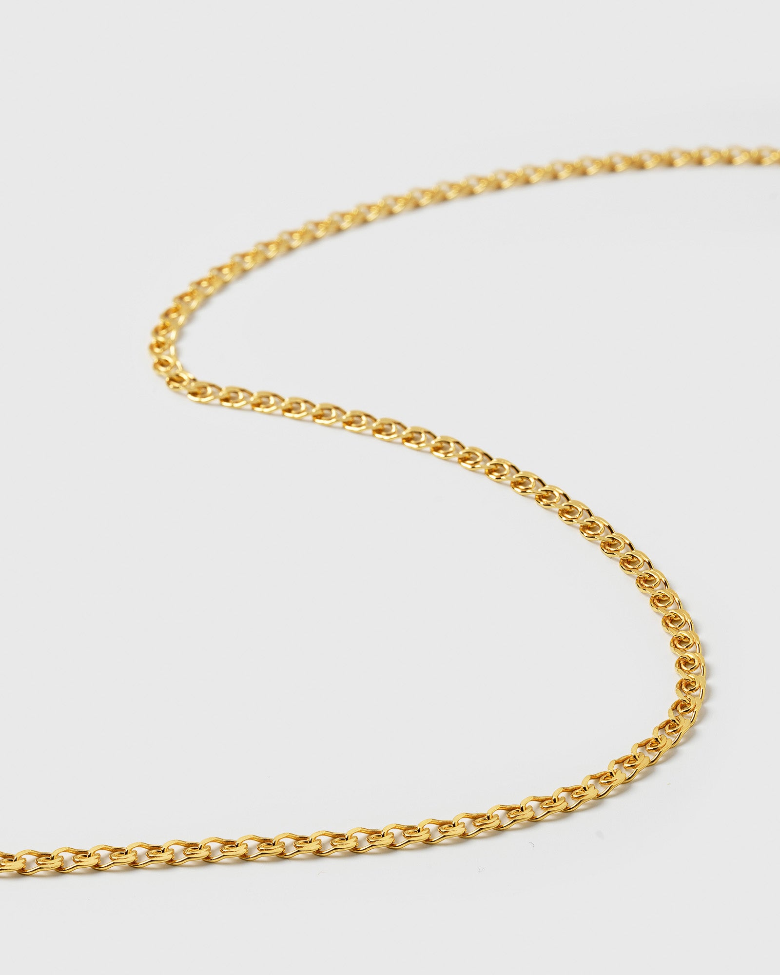 A close-up product shot of the Sheer Love Necklace in gold, highlighting the intricate patterned design of the chain.