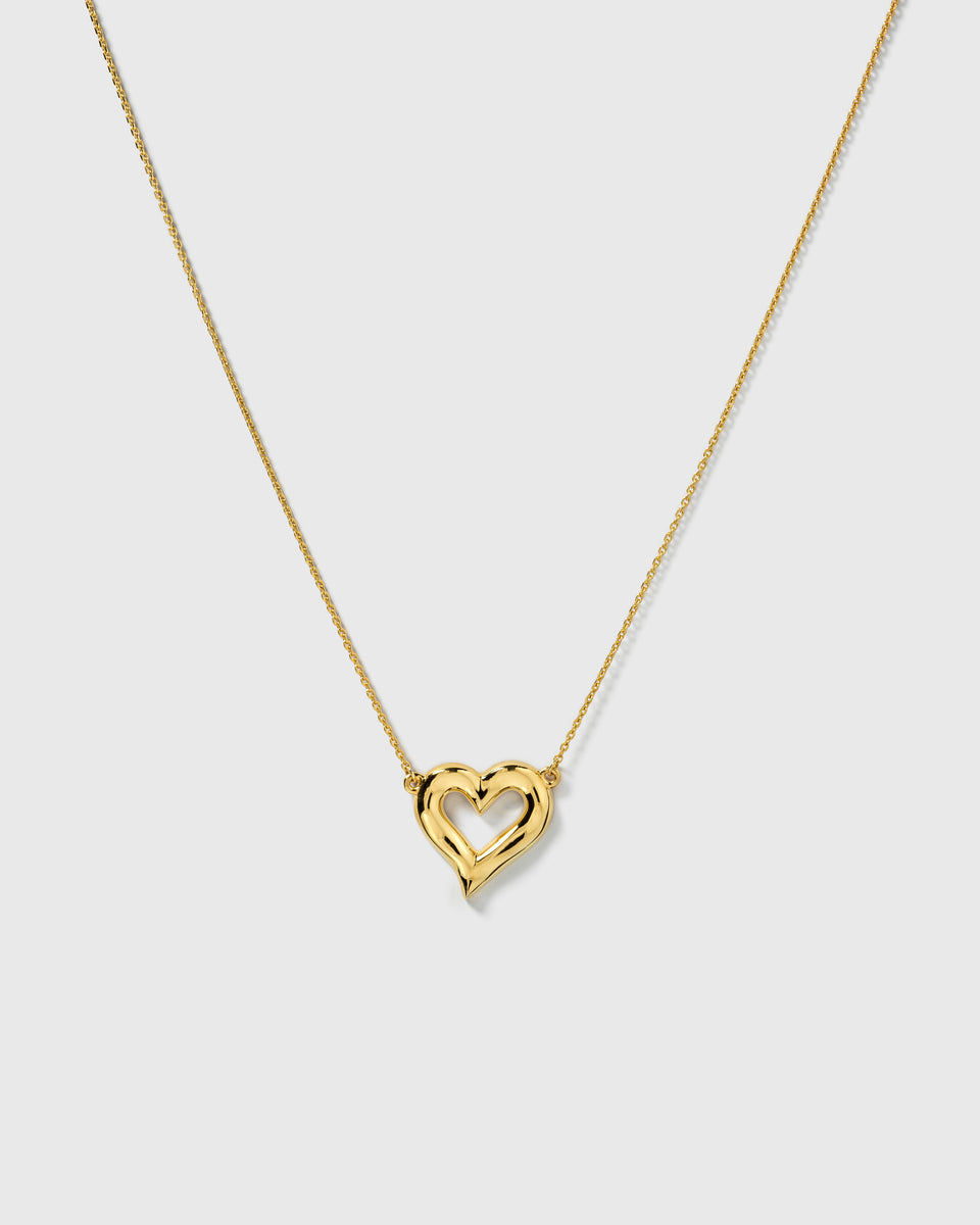 A product shot of the Puff Heart Necklace in gold, showcasing its chunky and organic heart-shaped pendant on a delicate chain.